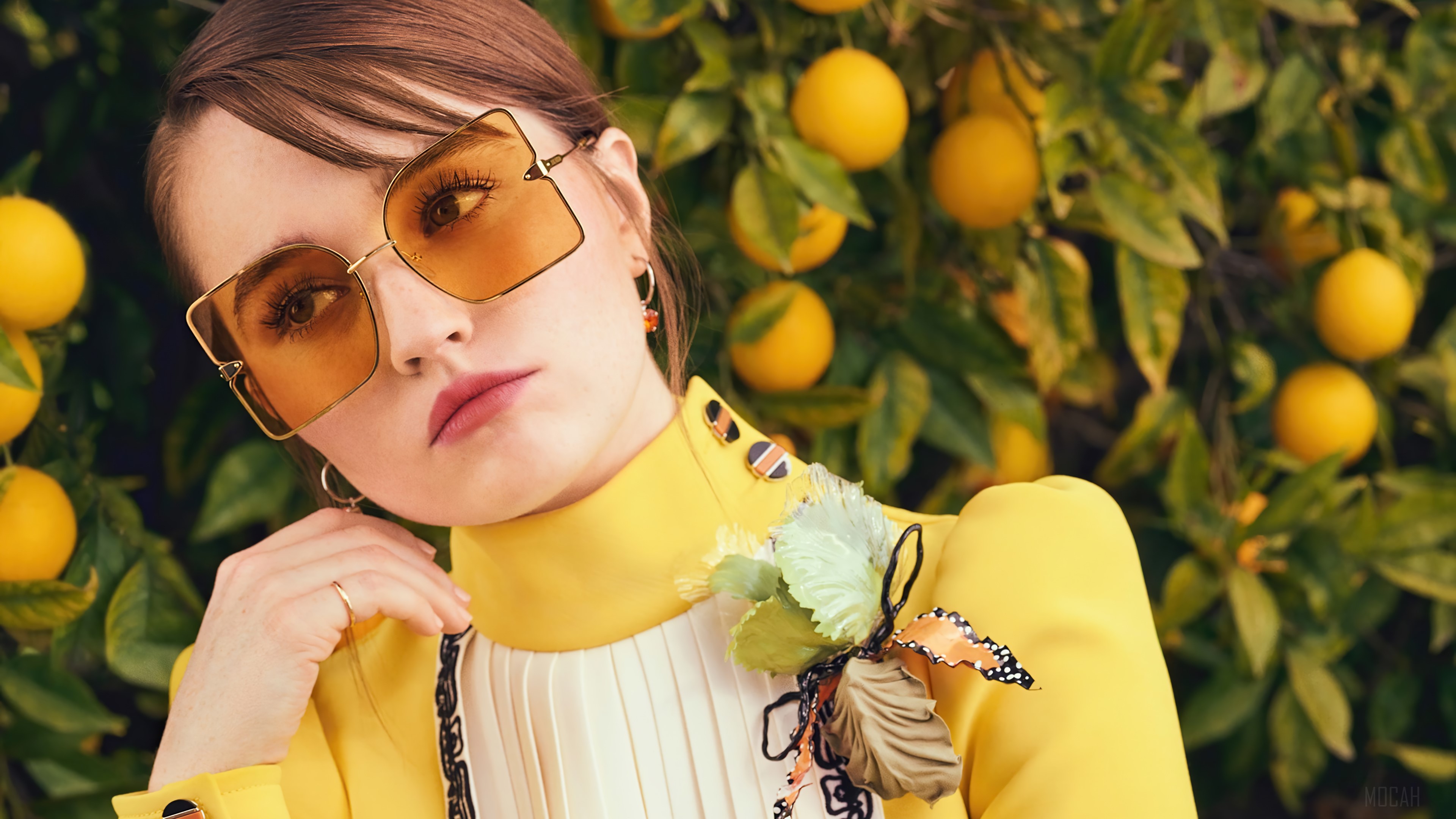Kaitlyn Dever wearing sunglasses with oranges in background HD Wallpaper