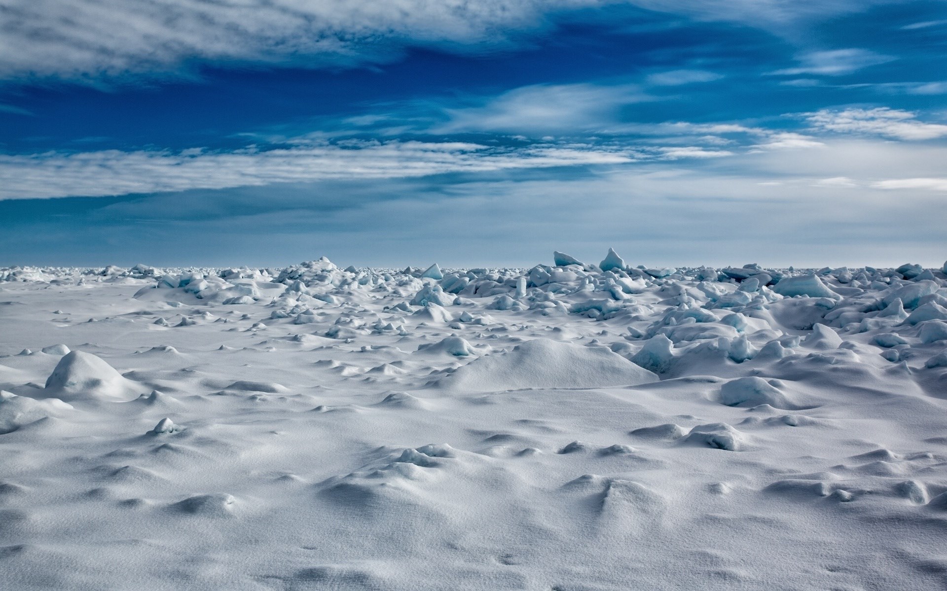 Arctic ice floes under a cloudy blue sky HD Wallpaper