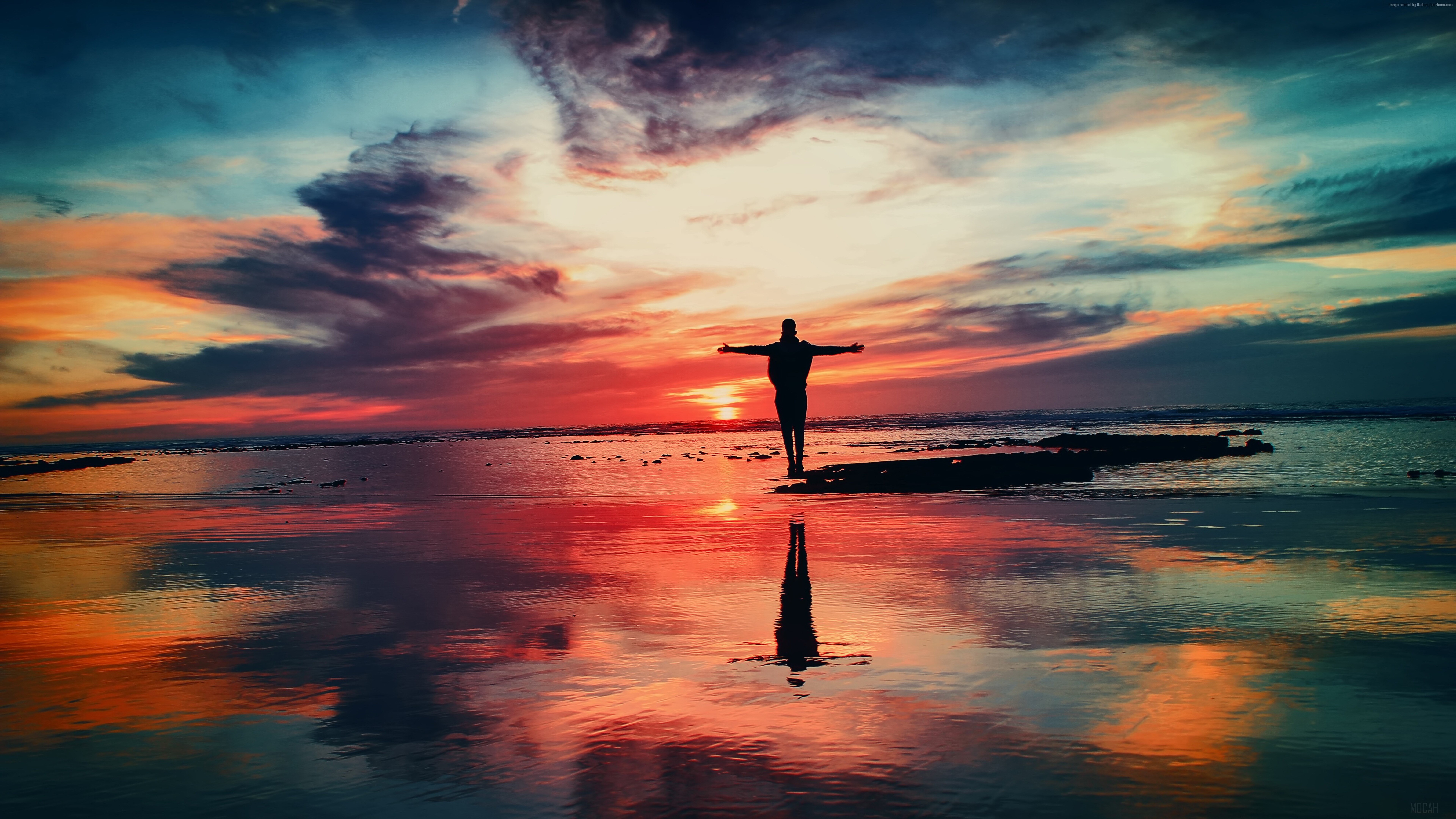 Man with arms outstretched at sunset over the sea HD Wallpaper