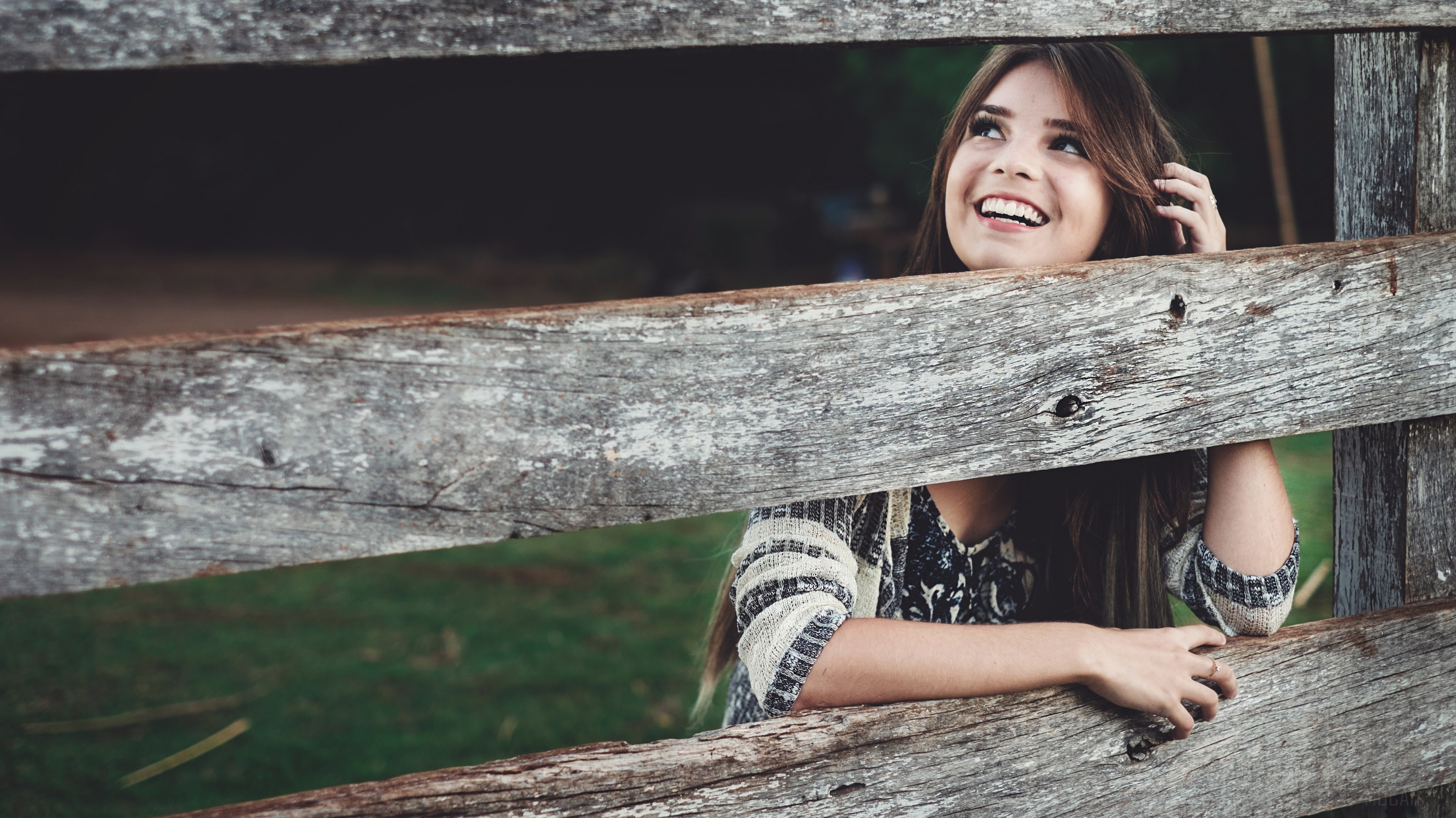 Young woman smiling behind a wooden fence HD Wallpaper