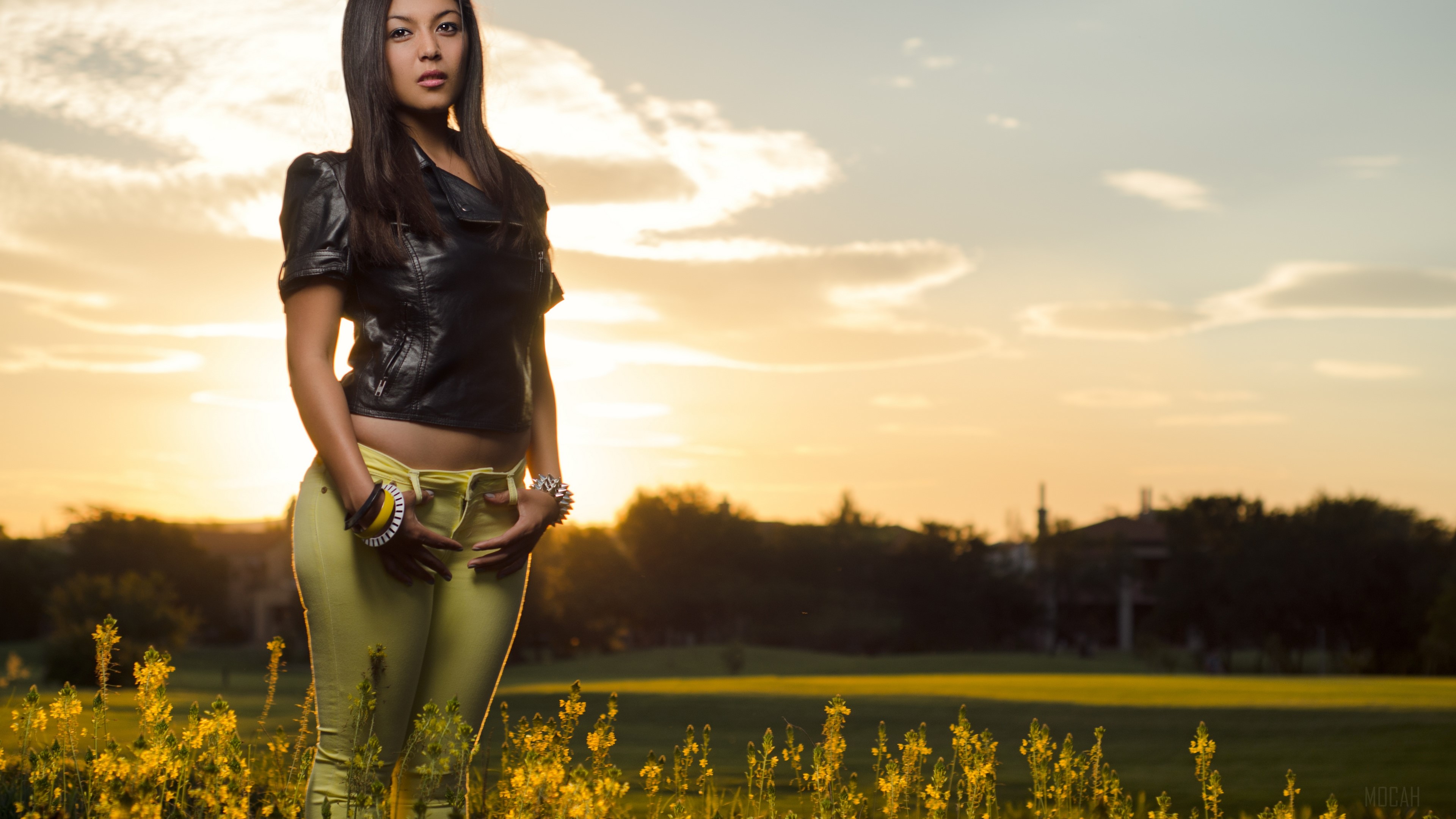 Woman in yellow pants and black jacket at sunset HD Wallpaper