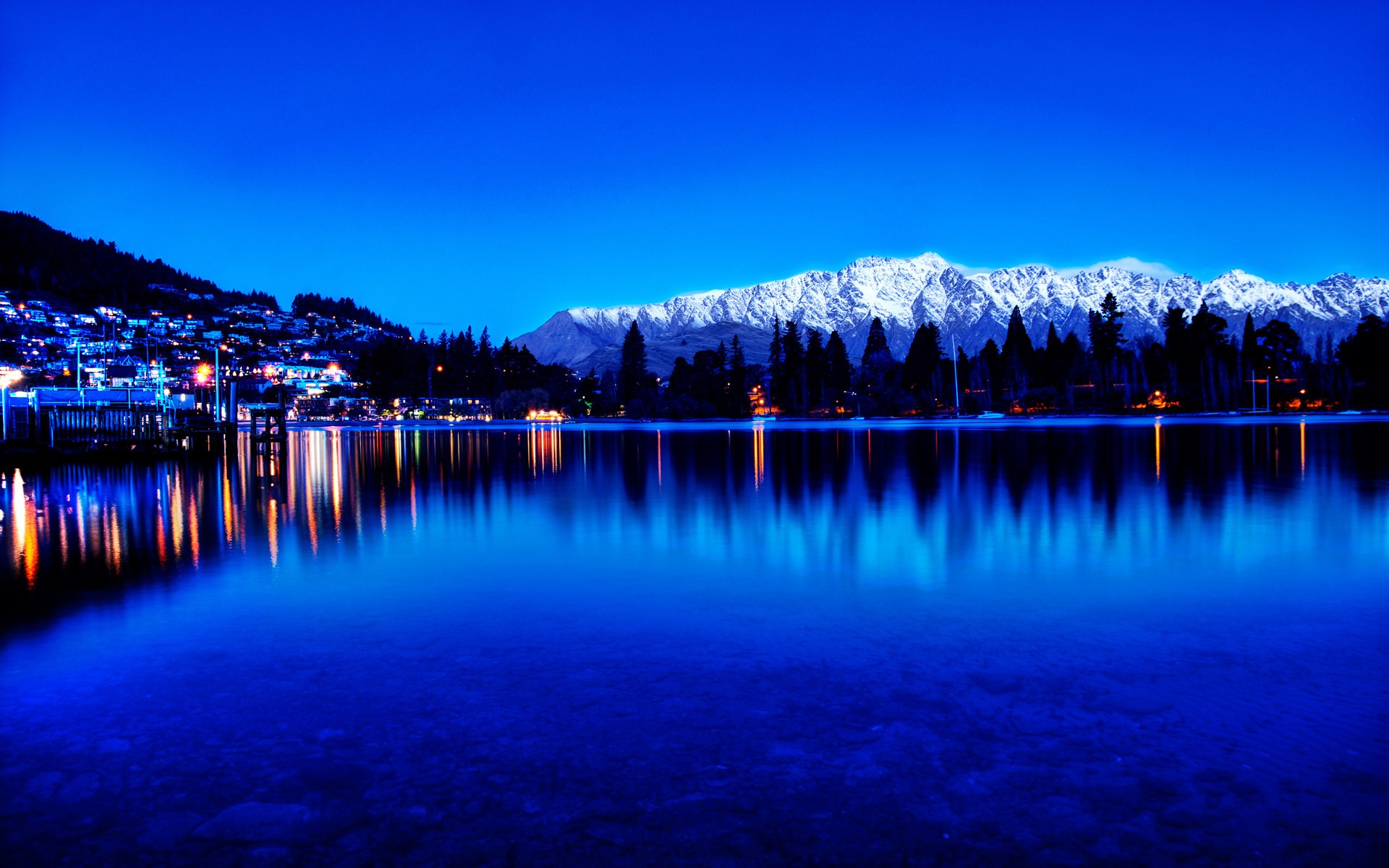 Snow-capped mountains reflected in a lake at dusk HD Wallpaper