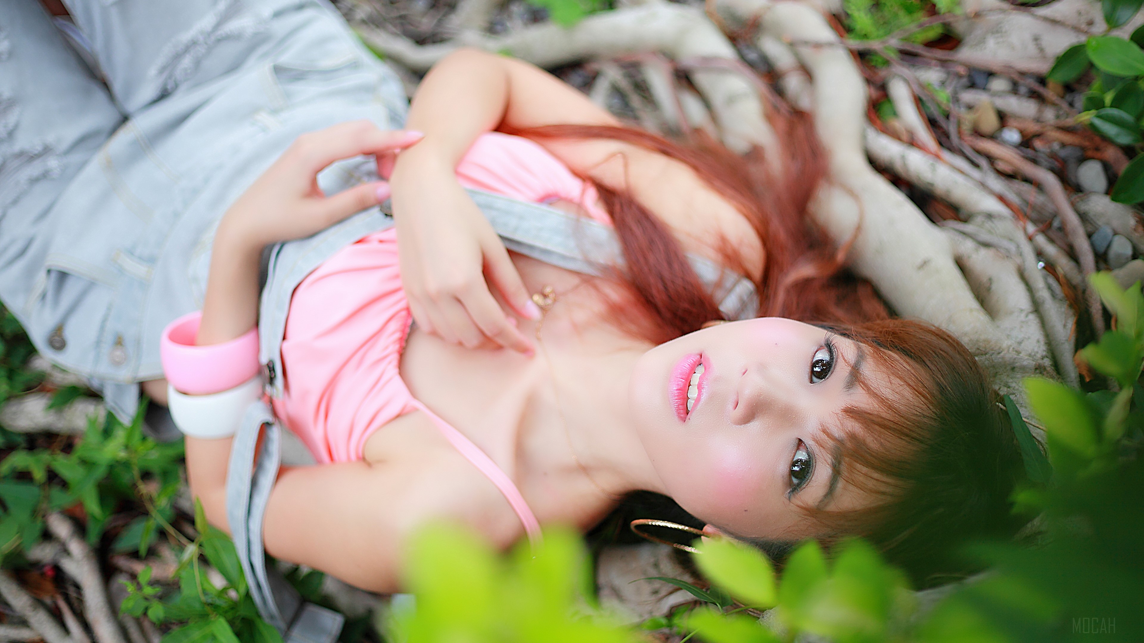 Woman in pink top and denim overalls lying down HD Wallpaper