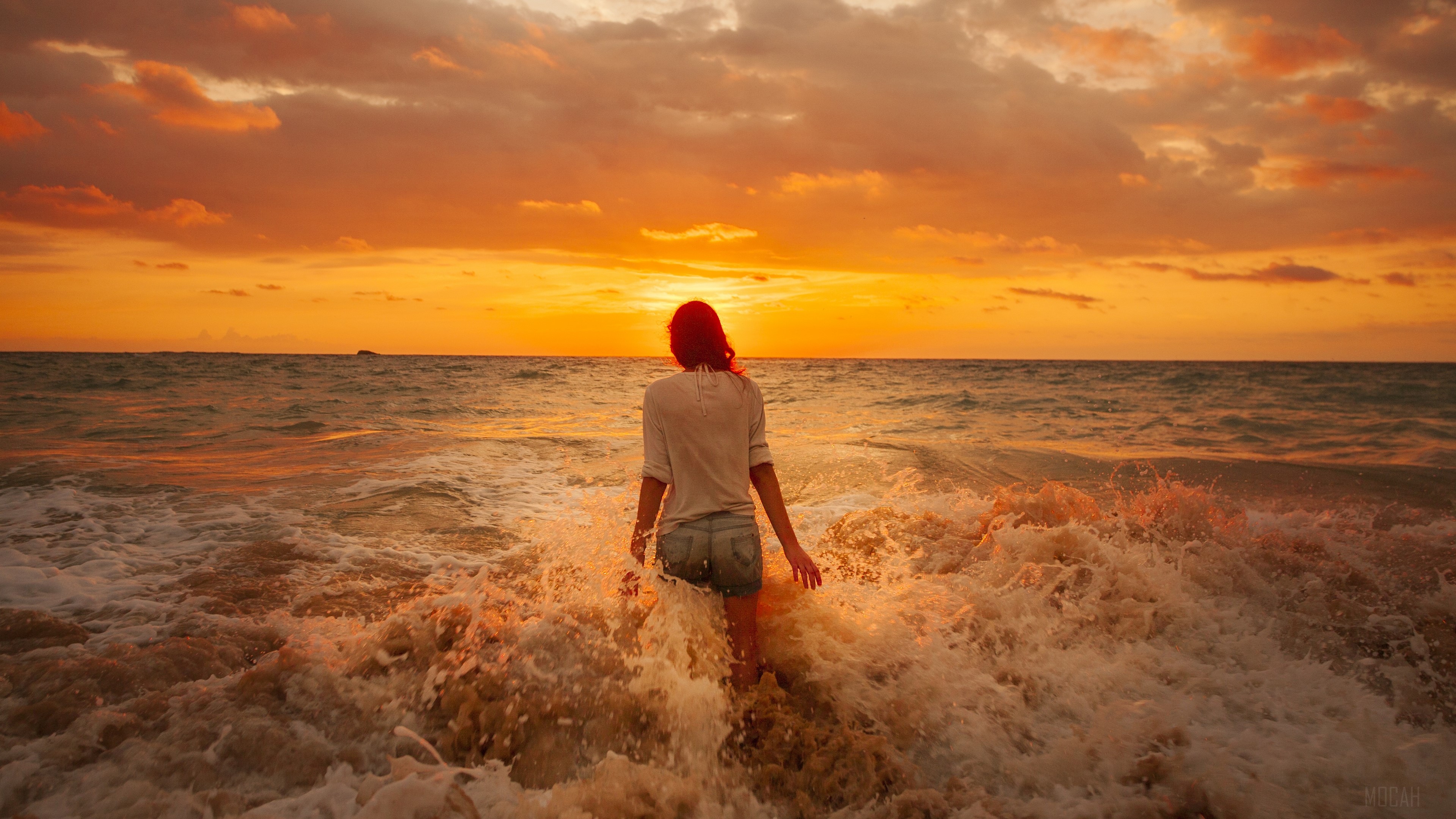 Woman walking into the ocean at sunset HD Wallpaper