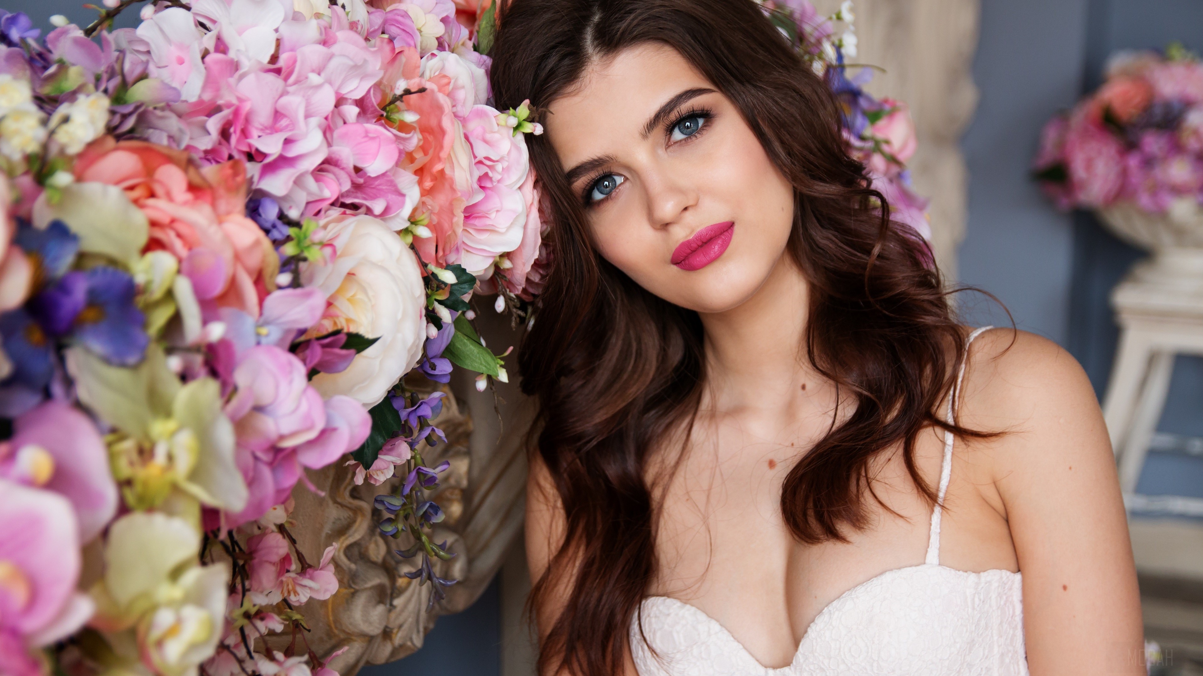Brunette woman with blue eyes and pink lipstick near flowers HD Wallpaper