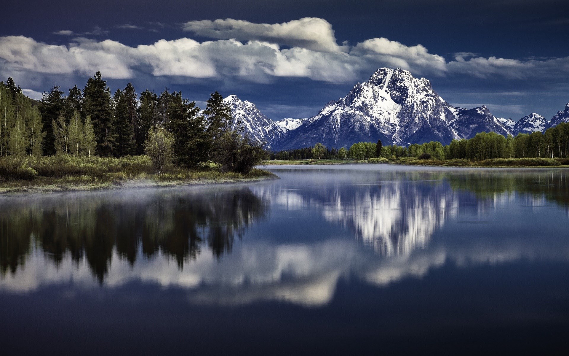 Snow-capped mountains reflected in a calm lake HD Wallpaper