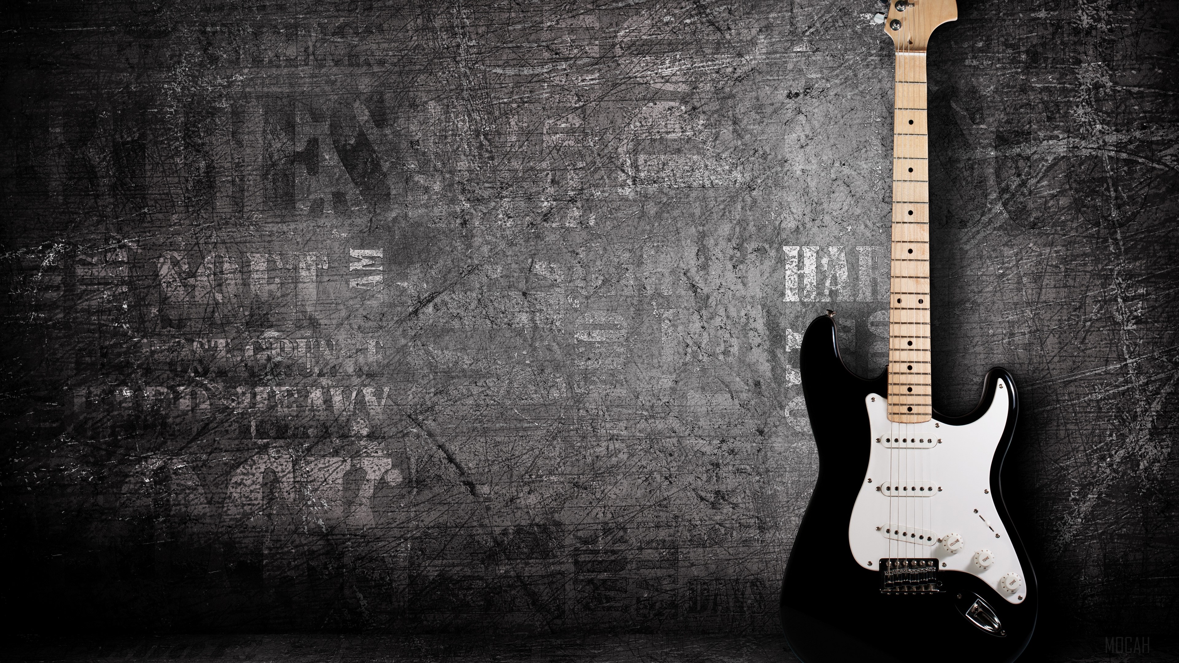Black electric guitar against a textured wall HD Wallpaper