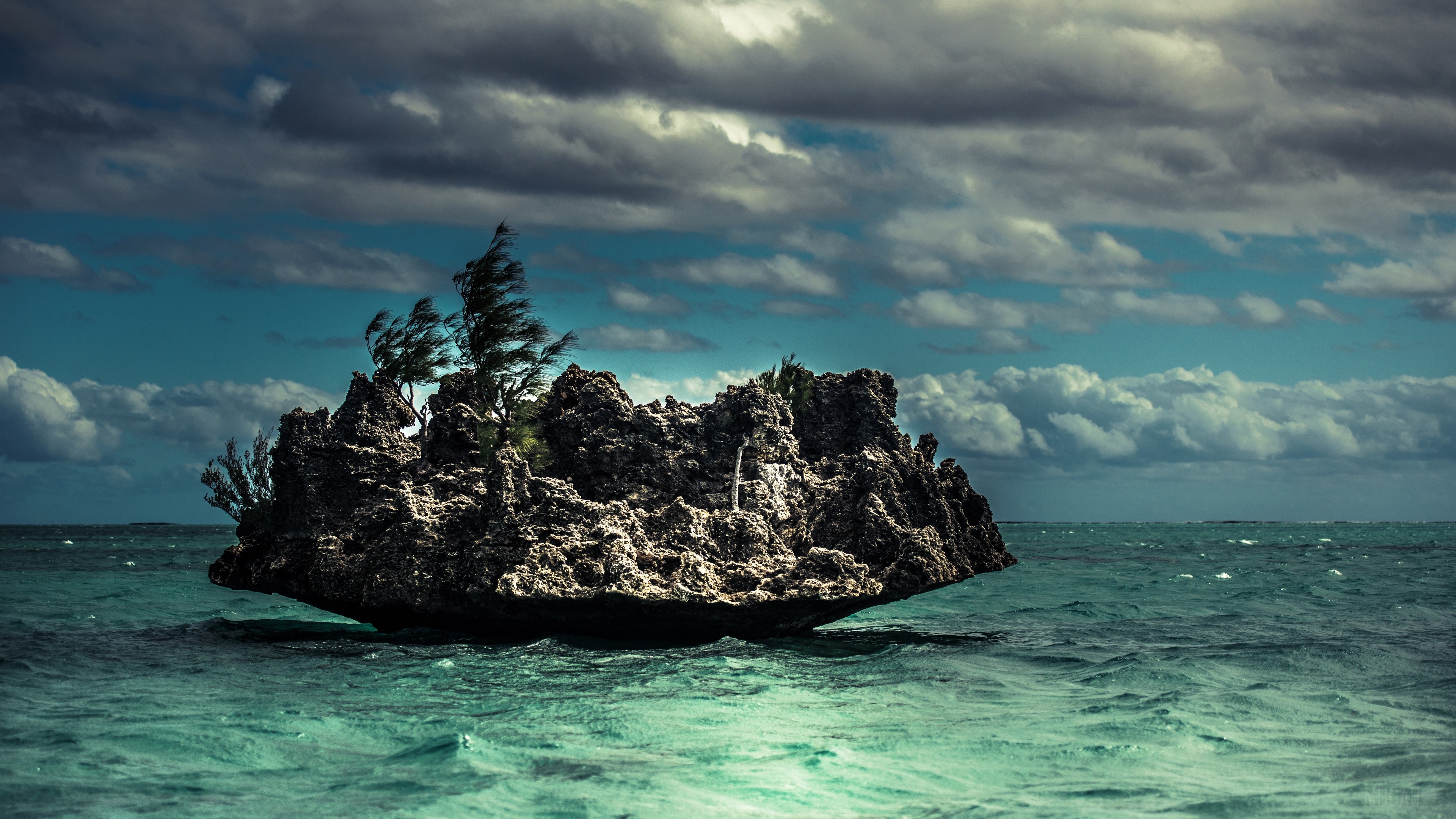 Rock formation in the ocean with clouds and waves 4K HD Wallpaper