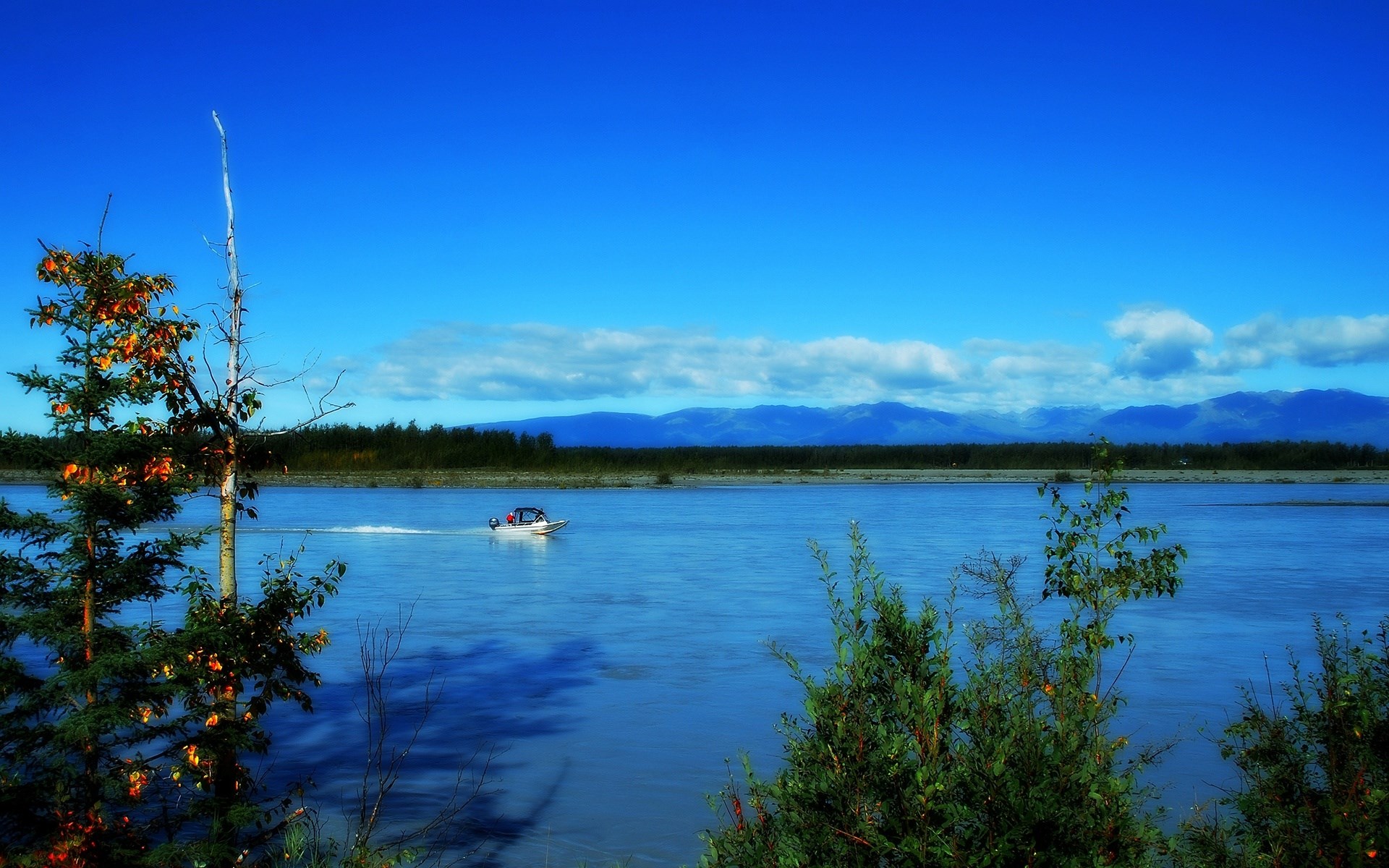 Boat on a wide river with mountains in the distance HD Wallpaper