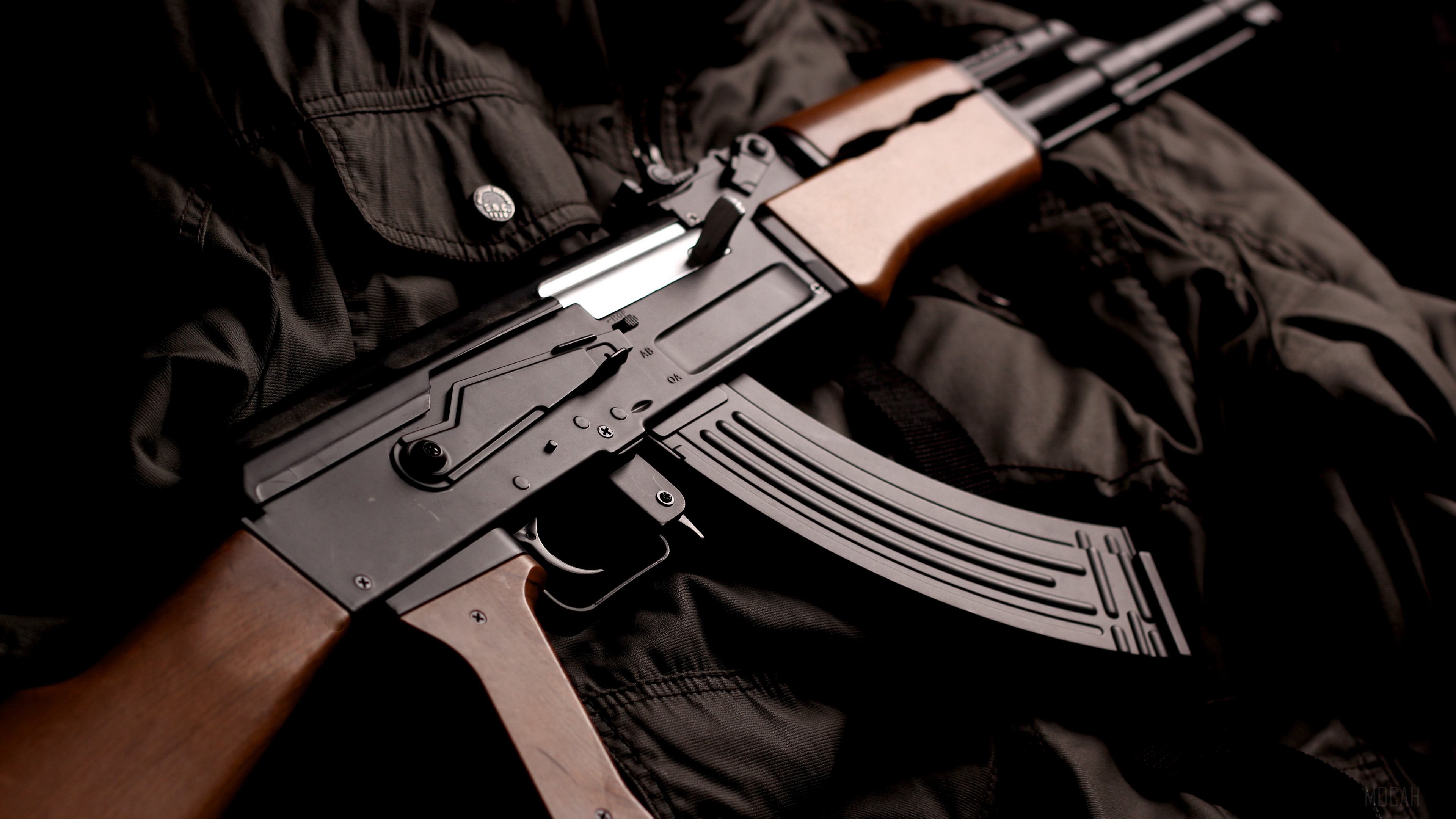 AK-47 assault rifle on dark fabric HD Wallpaper