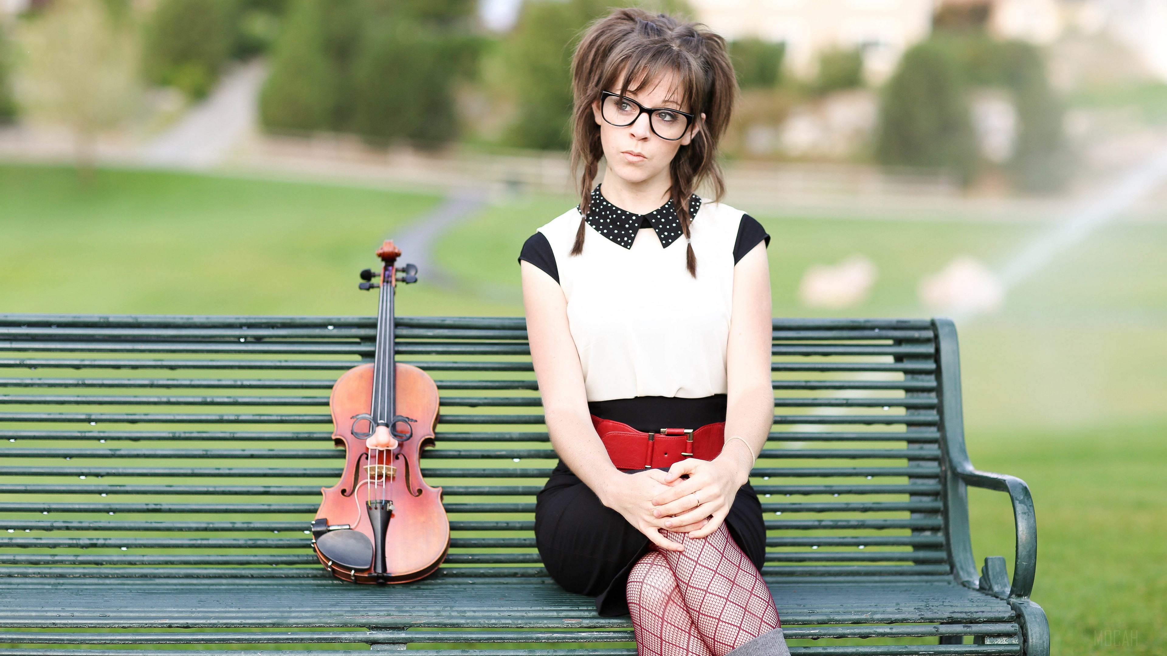 Woman with violin sitting on a park bench HD Wallpaper