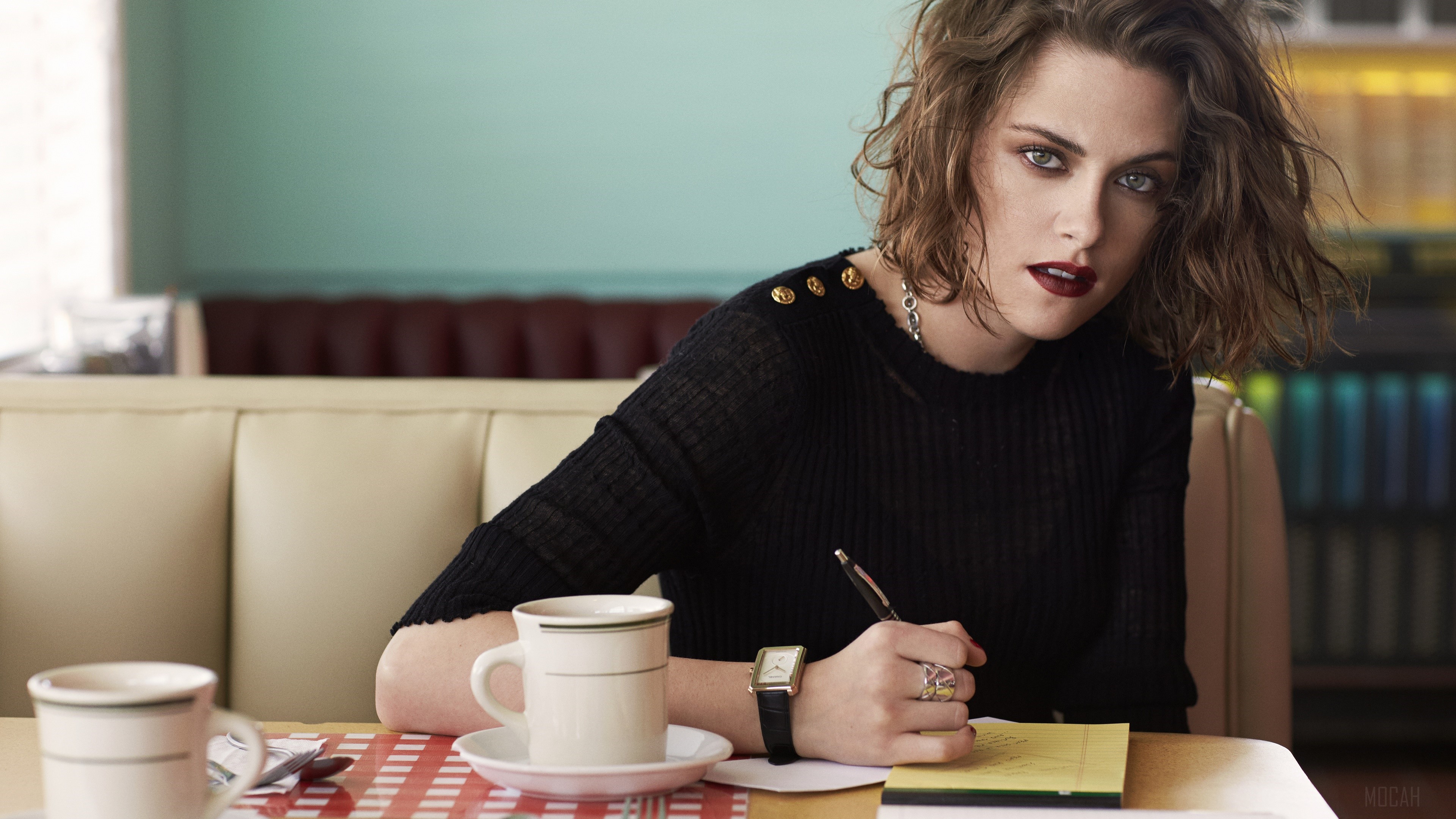 Kristen Stewart writing in a diner booth HD Wallpaper