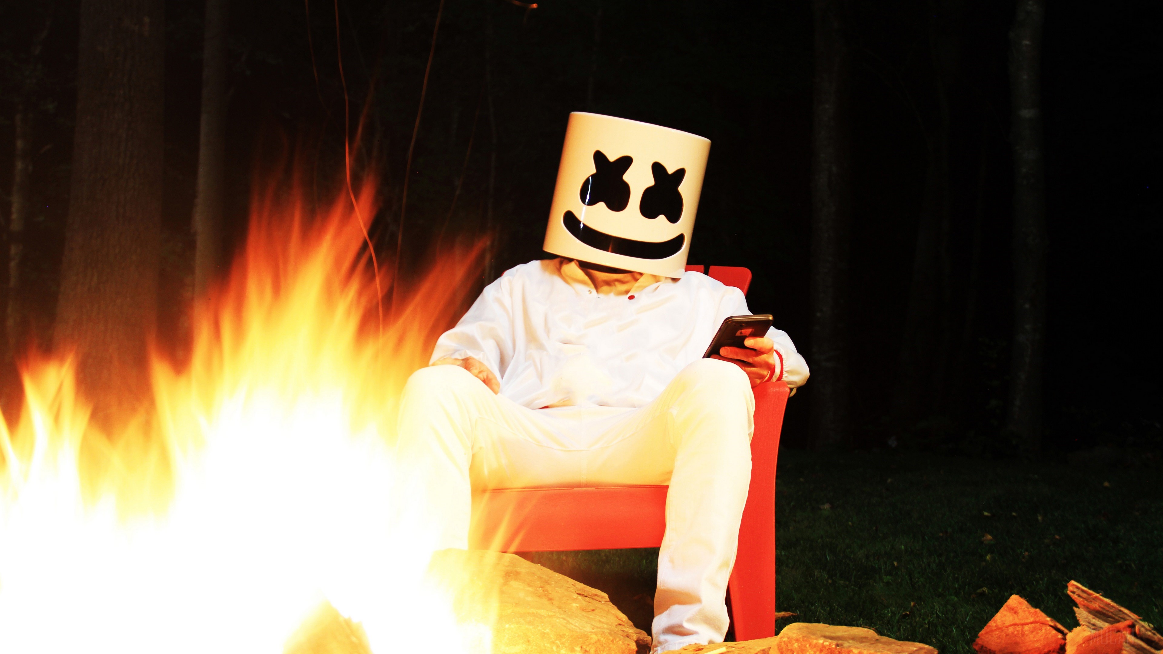 Marshmello sitting by a campfire at night HD Wallpaper
