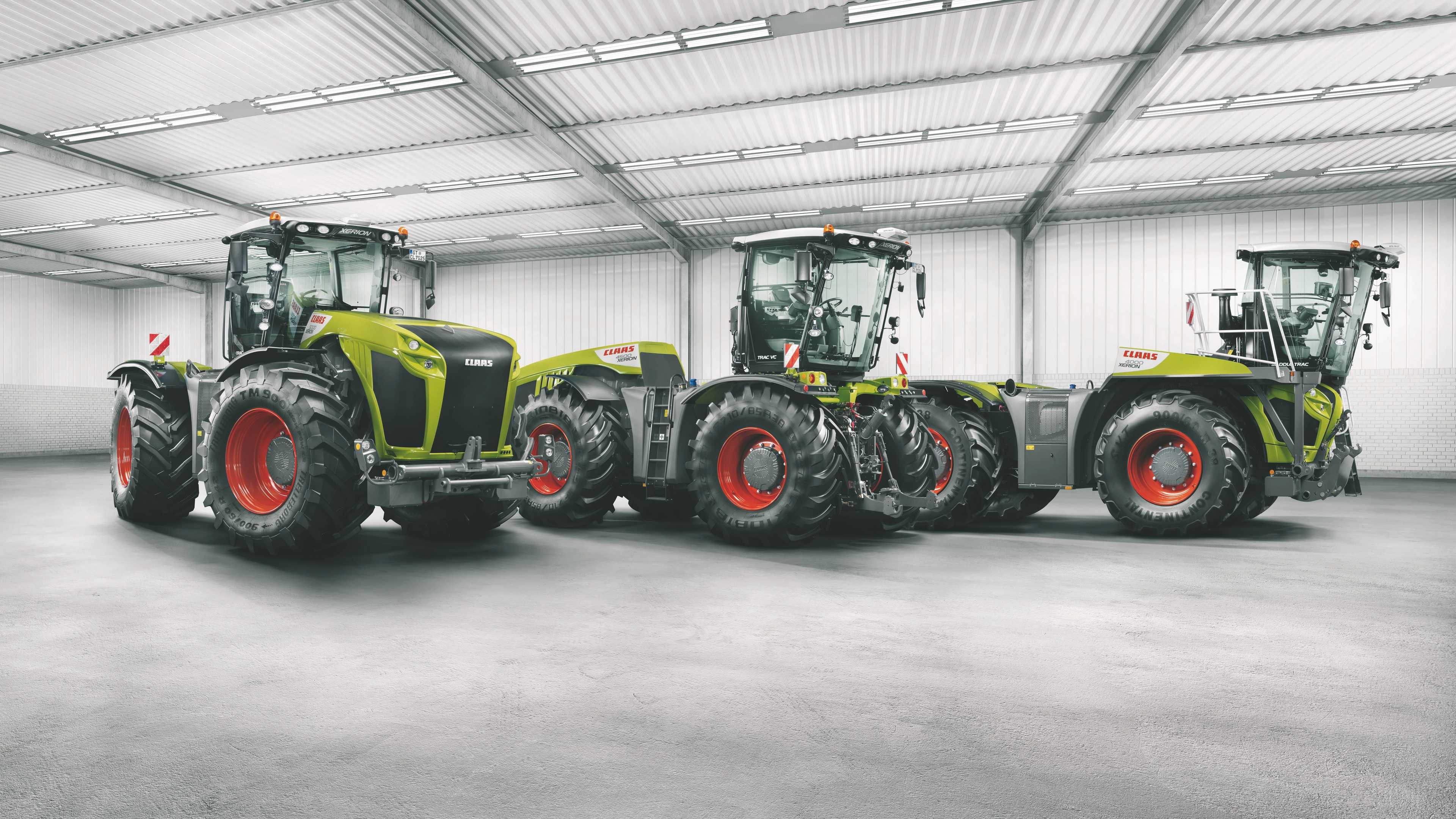Three Claas Xerion Tractors in a Warehouse HD Wallpaper