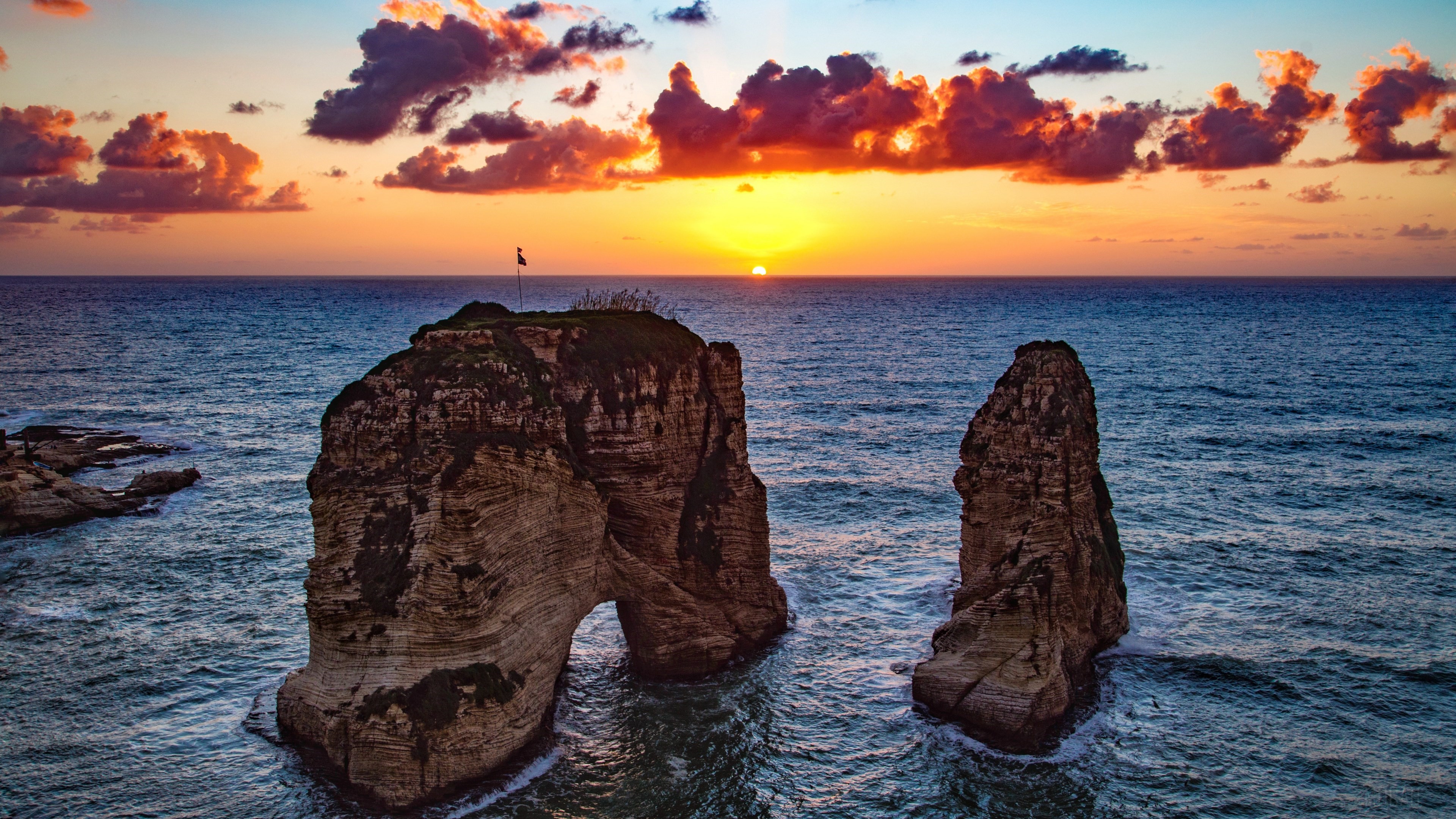 Rock formations in the ocean at sunrise HD Wallpaper