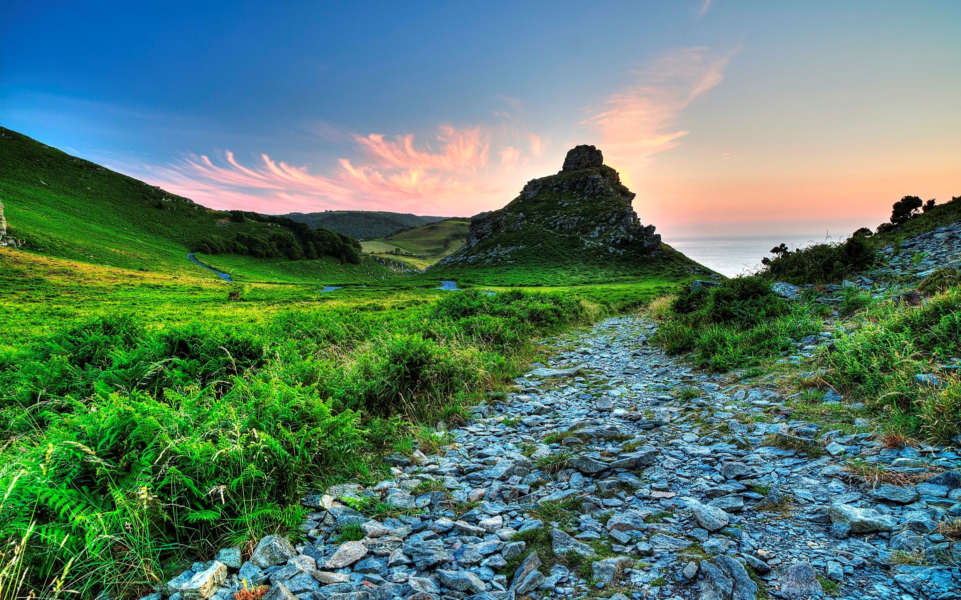 Rocky path leading to a rocky outcrop at sunset HD Wallpaper
