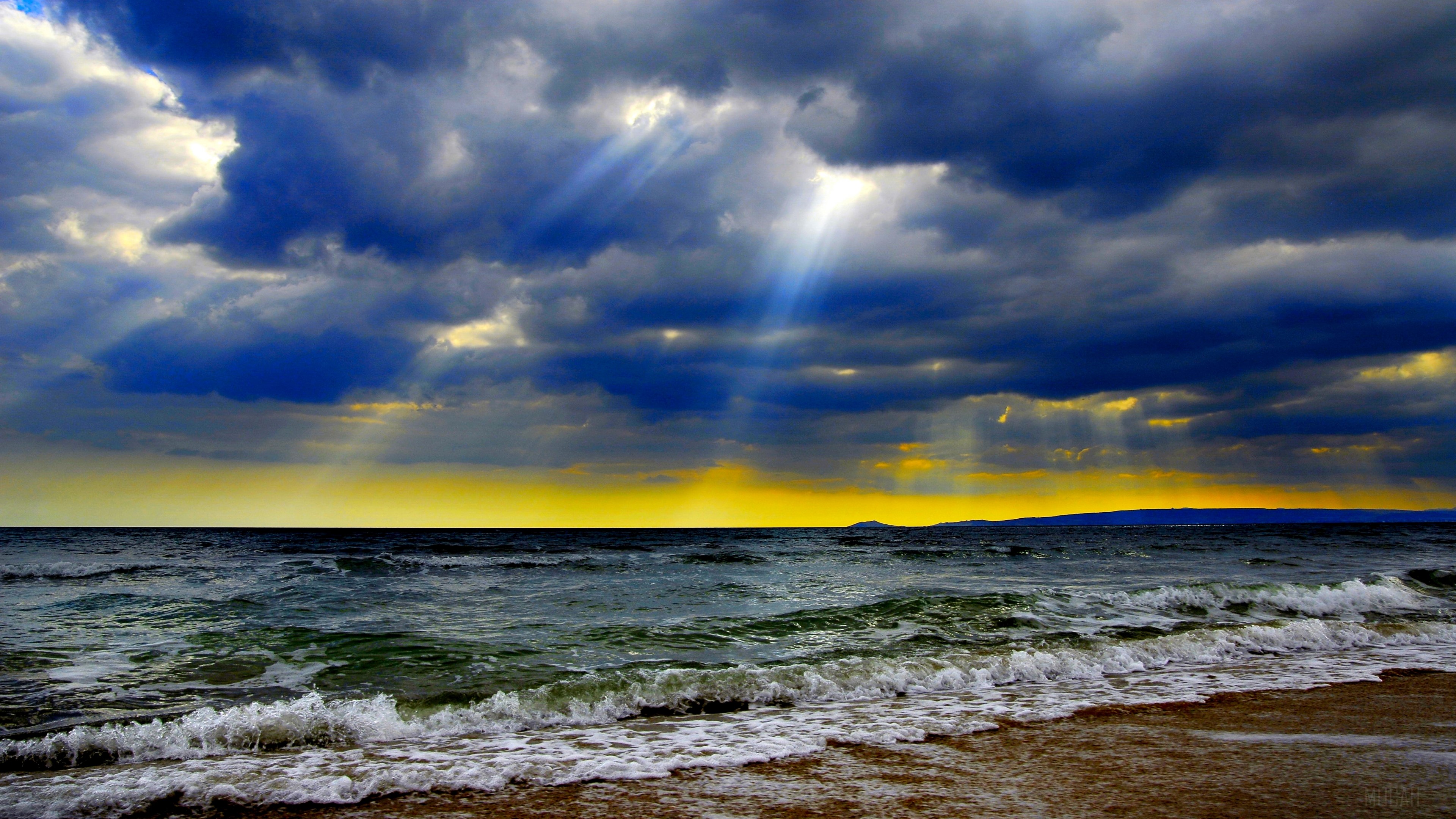 Sunbeams through dark clouds over the ocean HD Wallpaper