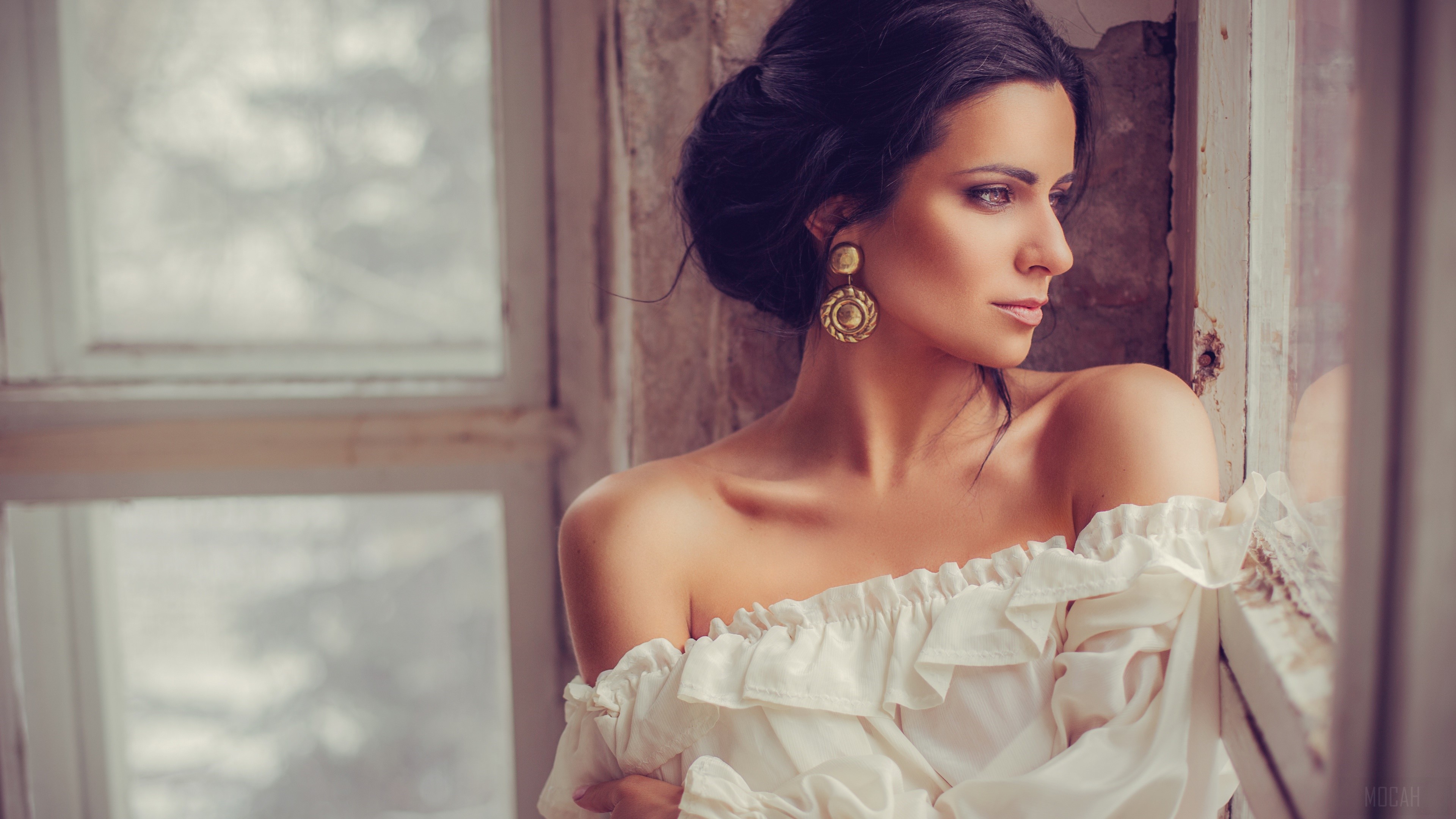Brunette woman with large earrings by window HD Wallpaper