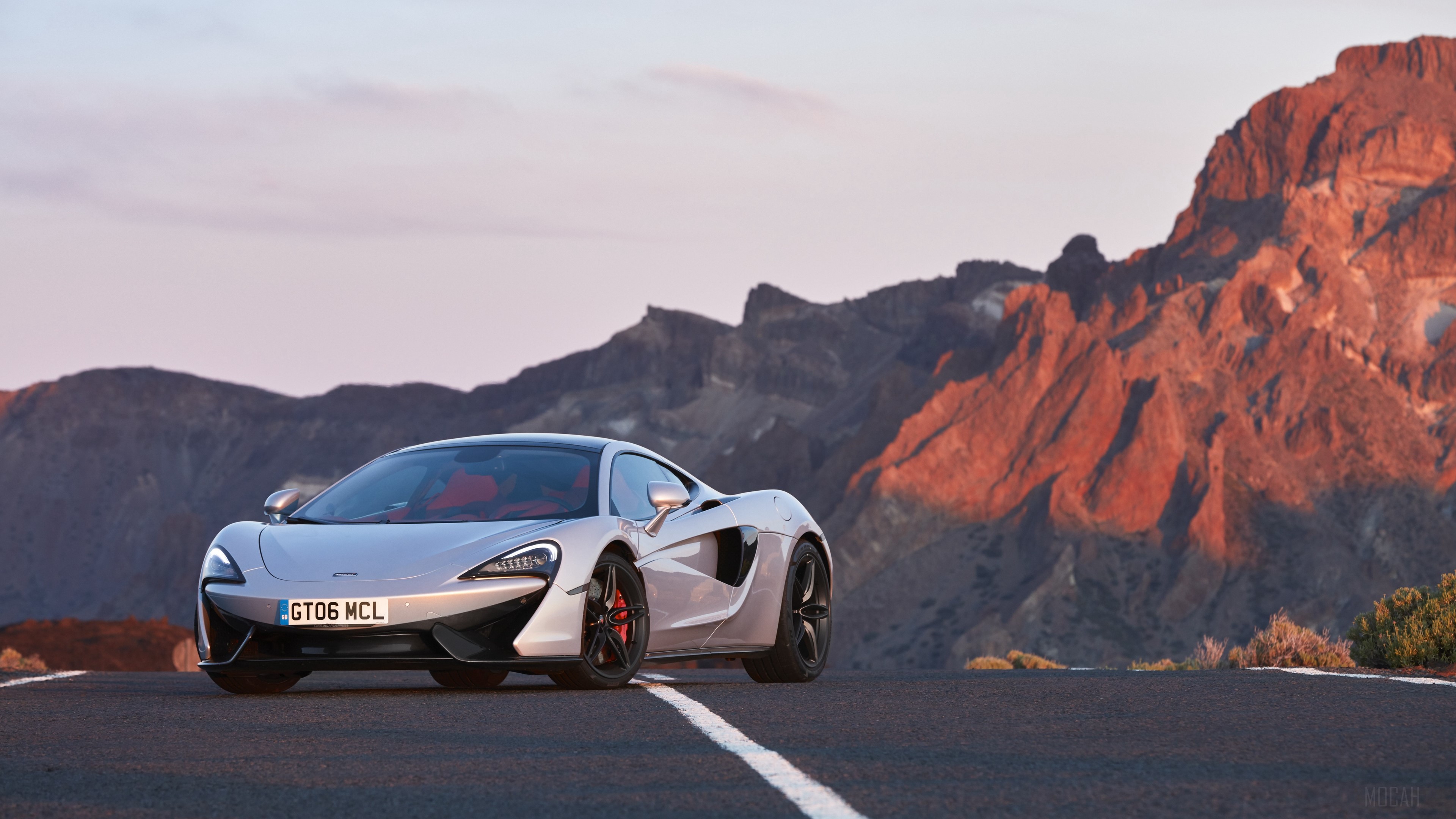 McLaren 570GT white sport car on mountain road HD Wallpaper