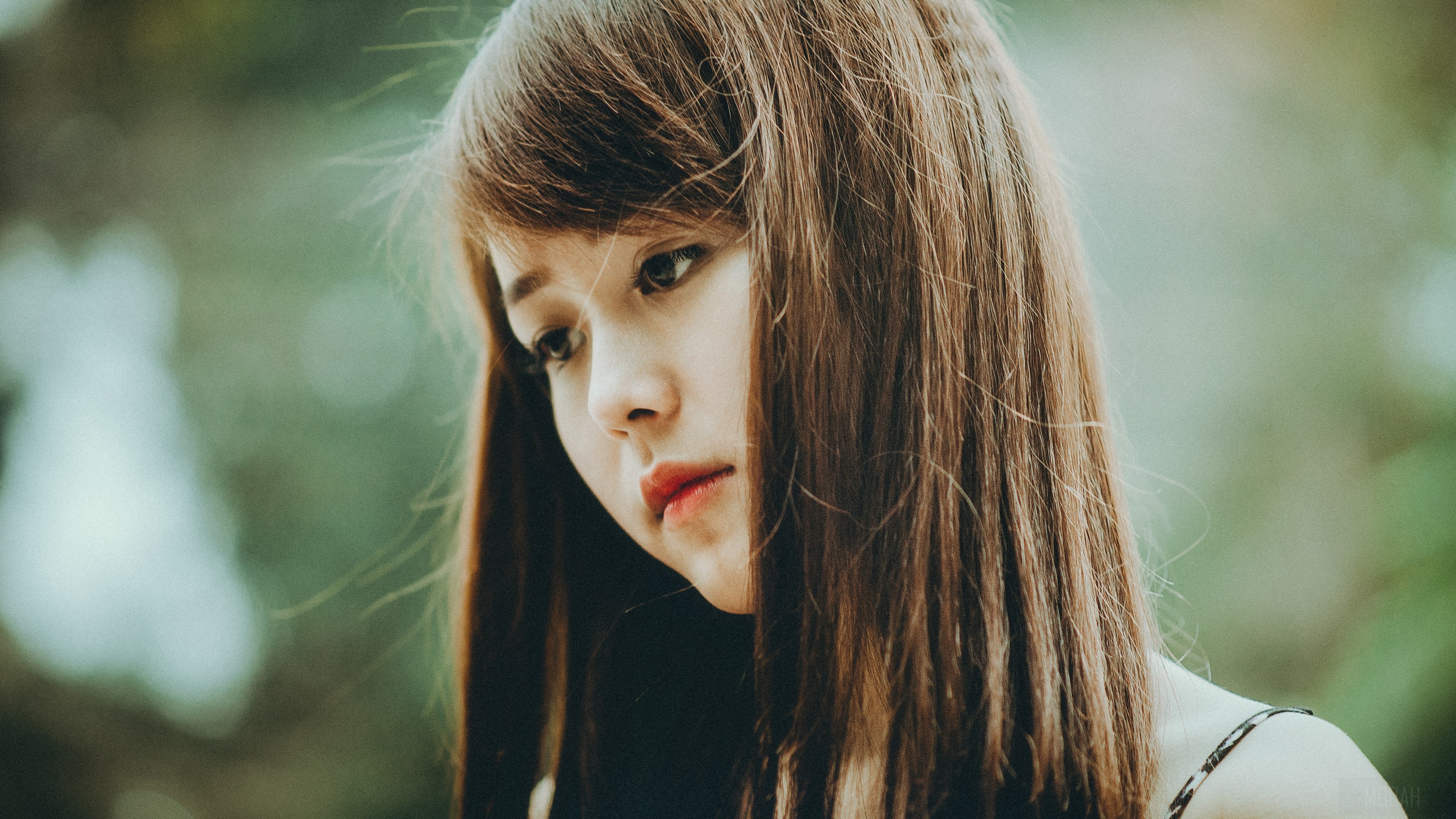 Young woman with brown hair looking down HD Wallpaper