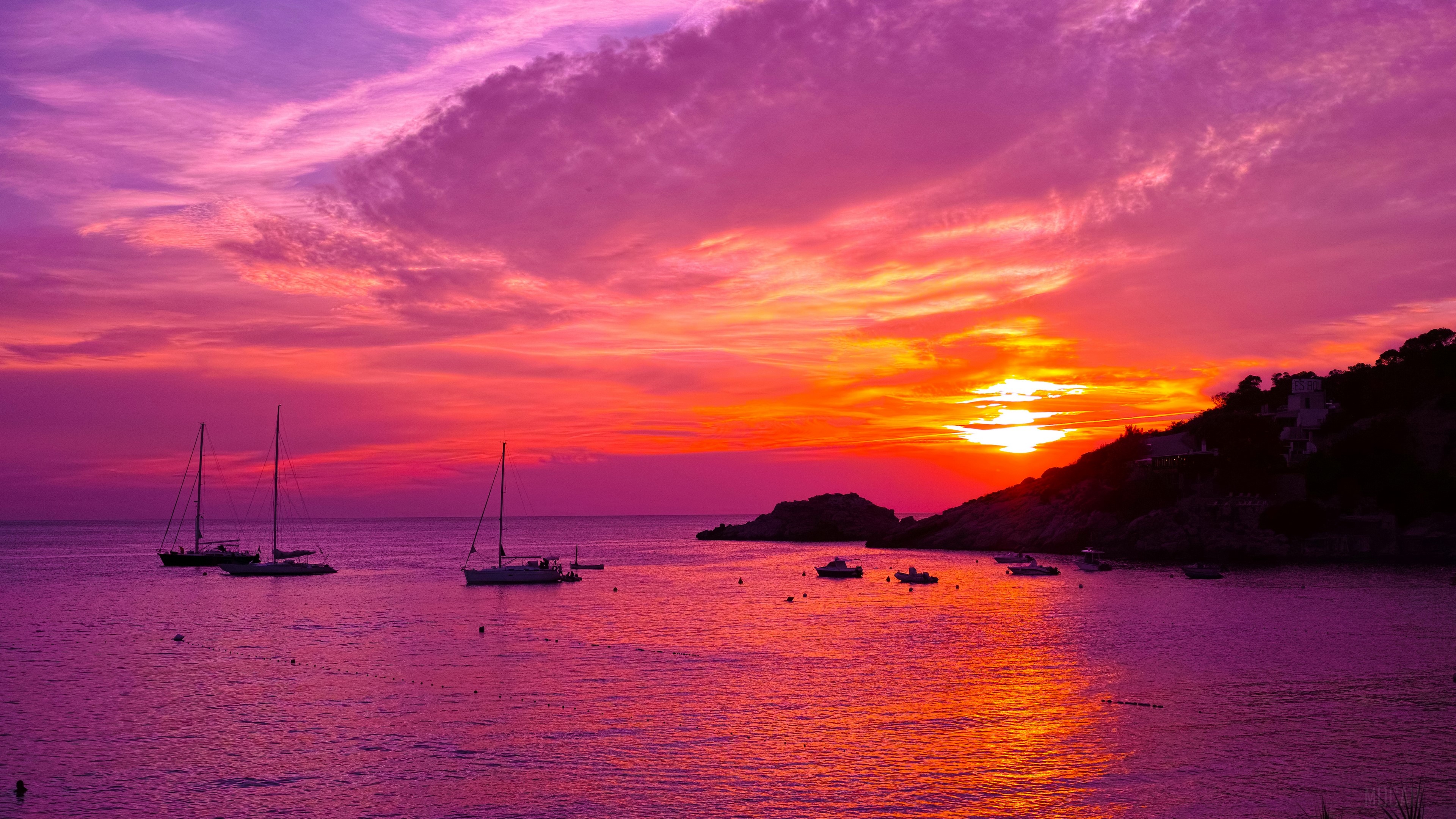 Boats in the ocean during a purple and orange sunset in Ibiza, Spain 4K HD Wallpaper