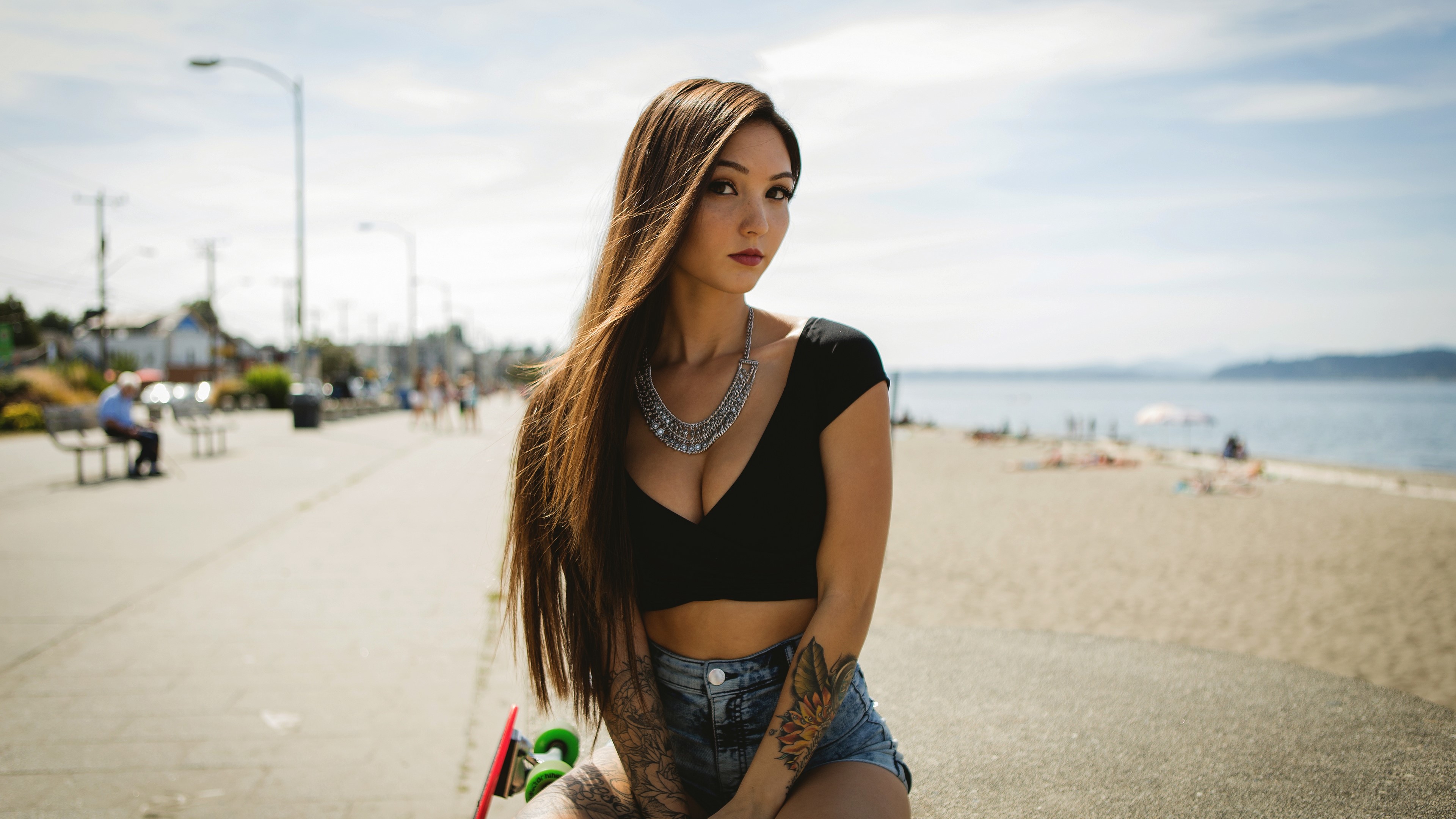 Woman with tattoos and necklace on a boardwalk HD Wallpaper