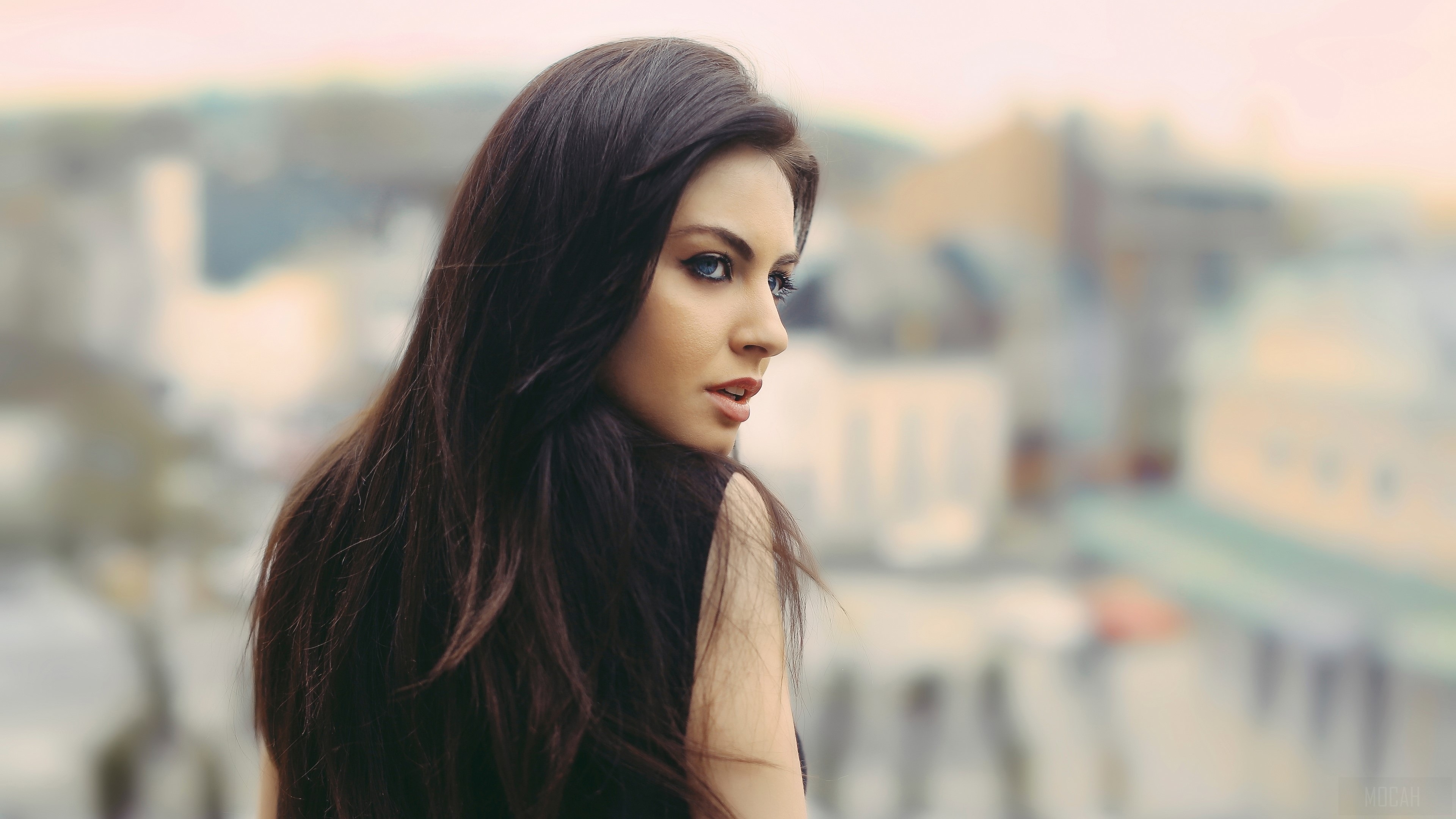 Woman with dark hair looking over her shoulder HD Wallpaper