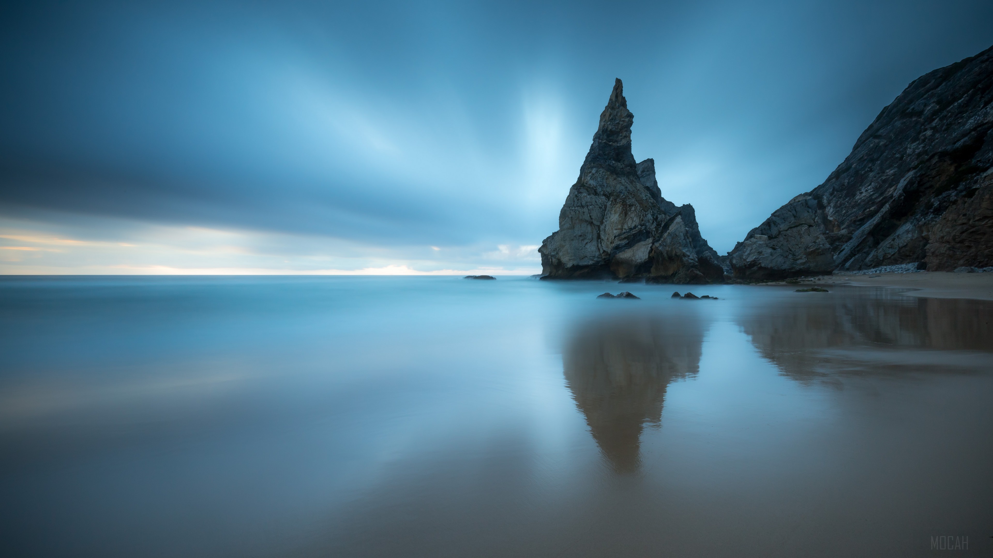 Tall rock formation in the ocean at dusk HD Wallpaper