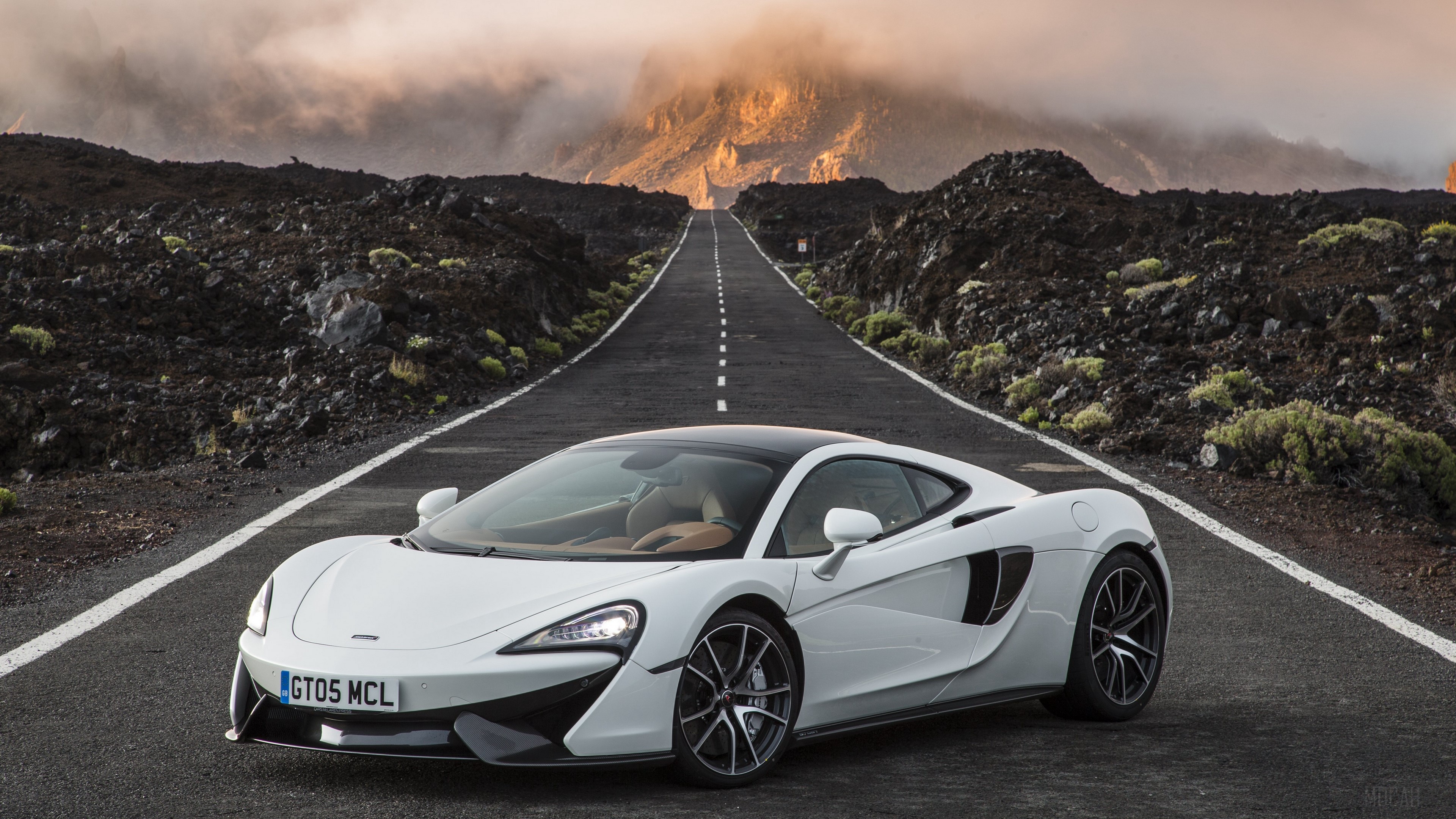 White McLaren 570GT on a mountain road HD Wallpaper