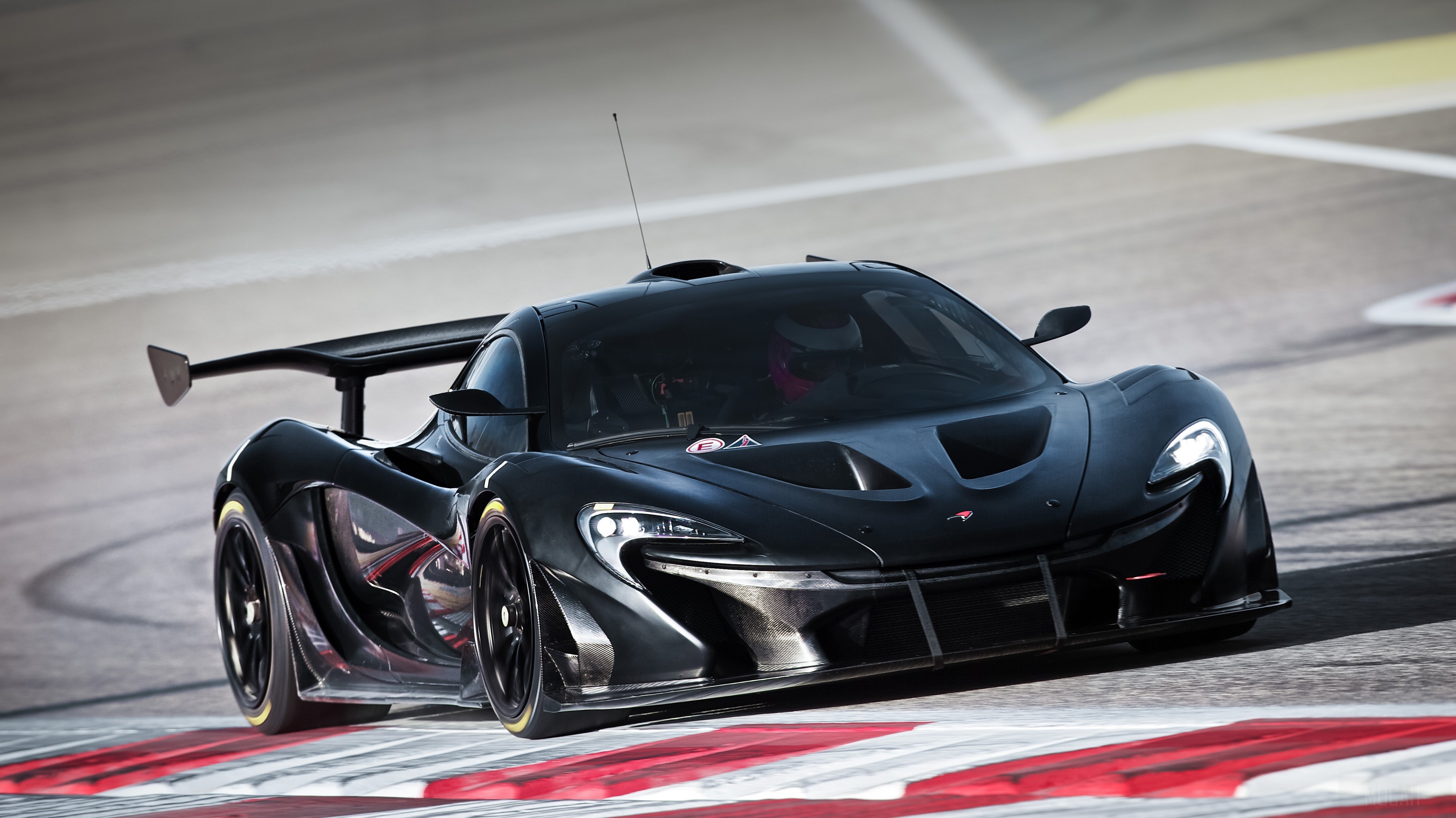 Black McLaren P1 GTR on a race track HD Wallpaper