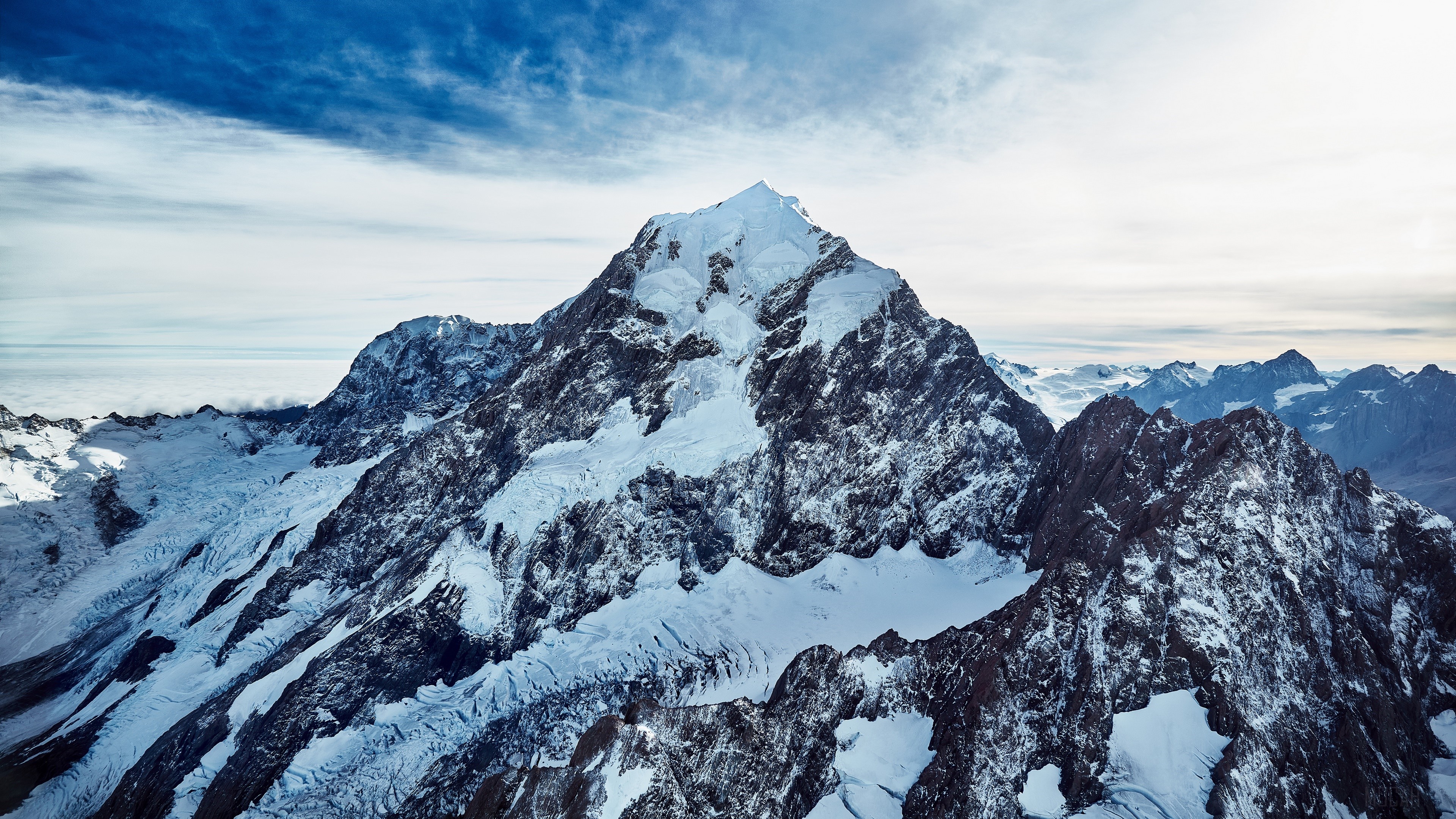 Snow-covered mountain peak under a blue sky HD Wallpaper