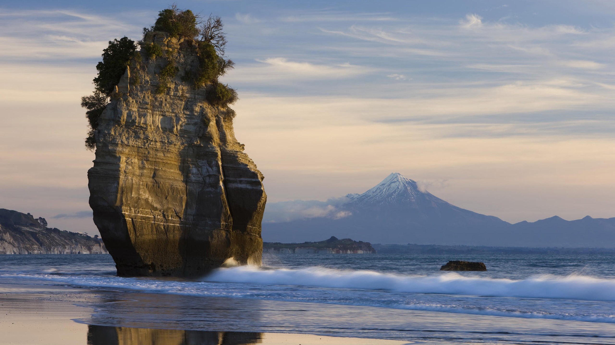 Rock formation and Mount Taranaki at sunset HD Wallpaper