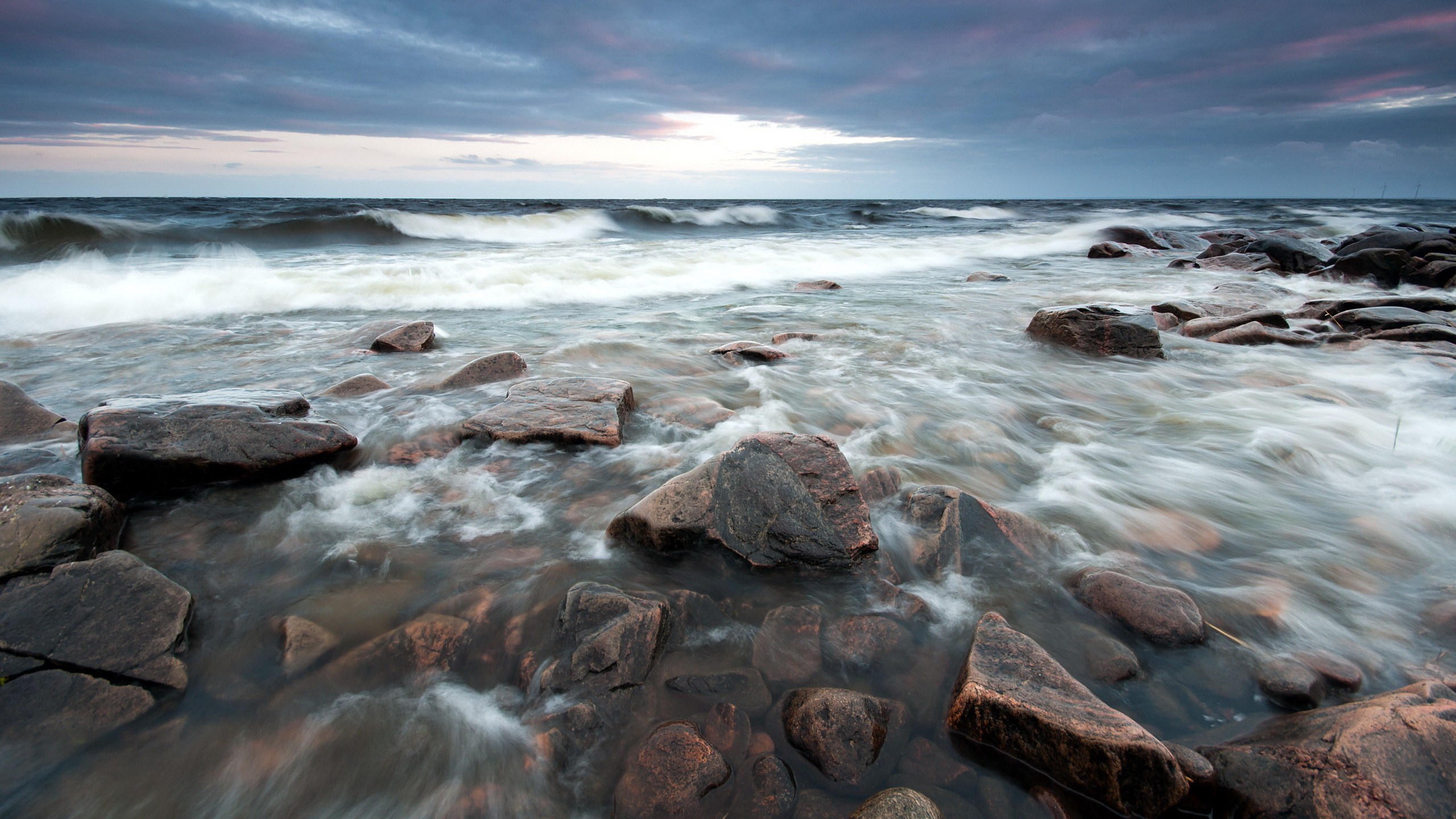 Waves crashing on rocky shore at dusk HD Wallpaper