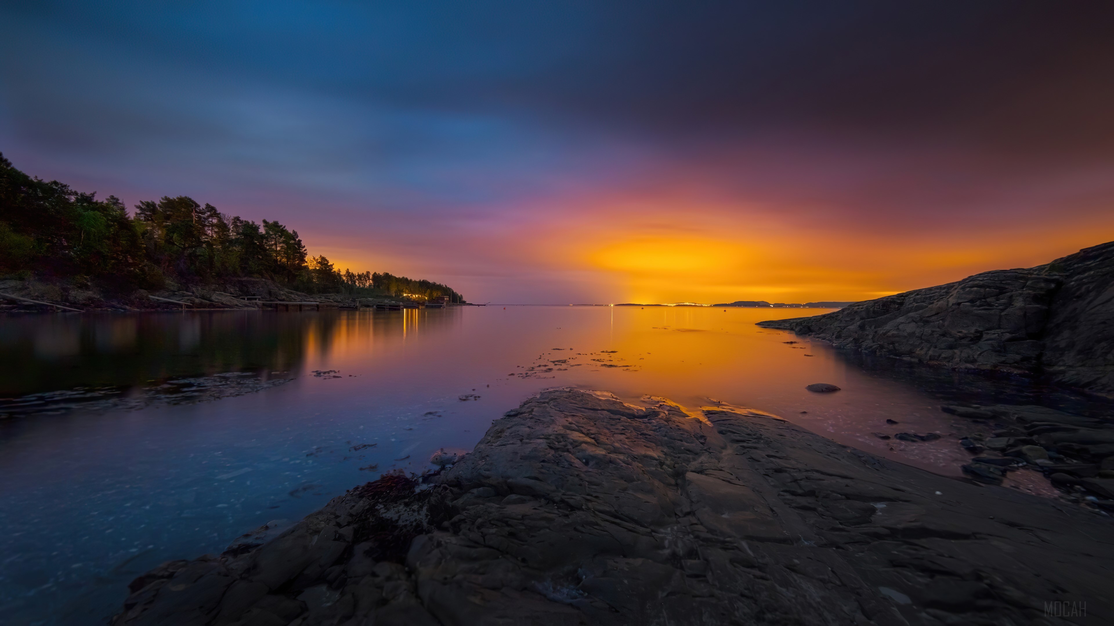 Sunset over a calm bay with rocky shores HD Wallpaper