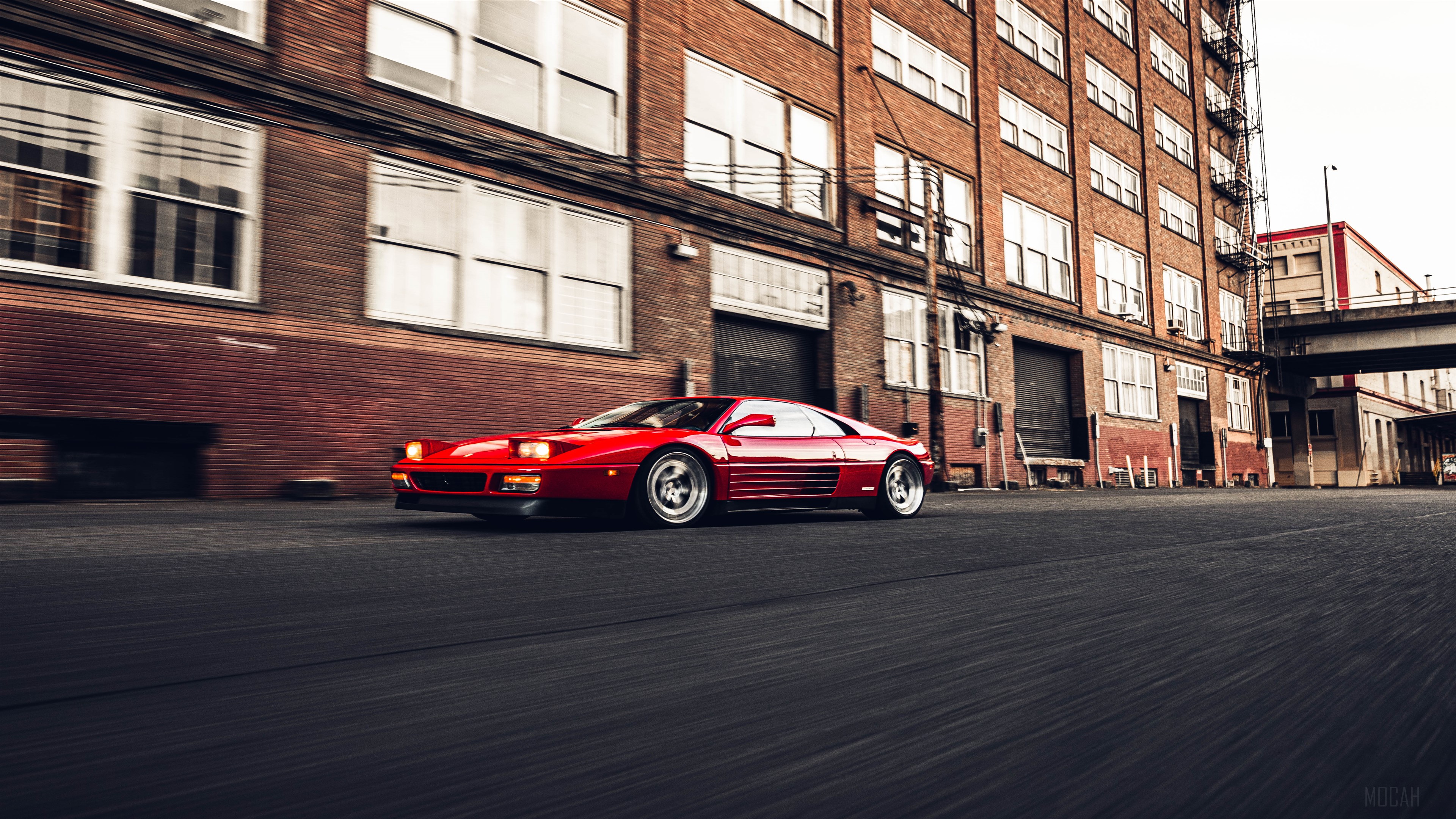 Red Ferrari 348 driving down an urban street HD Wallpaper