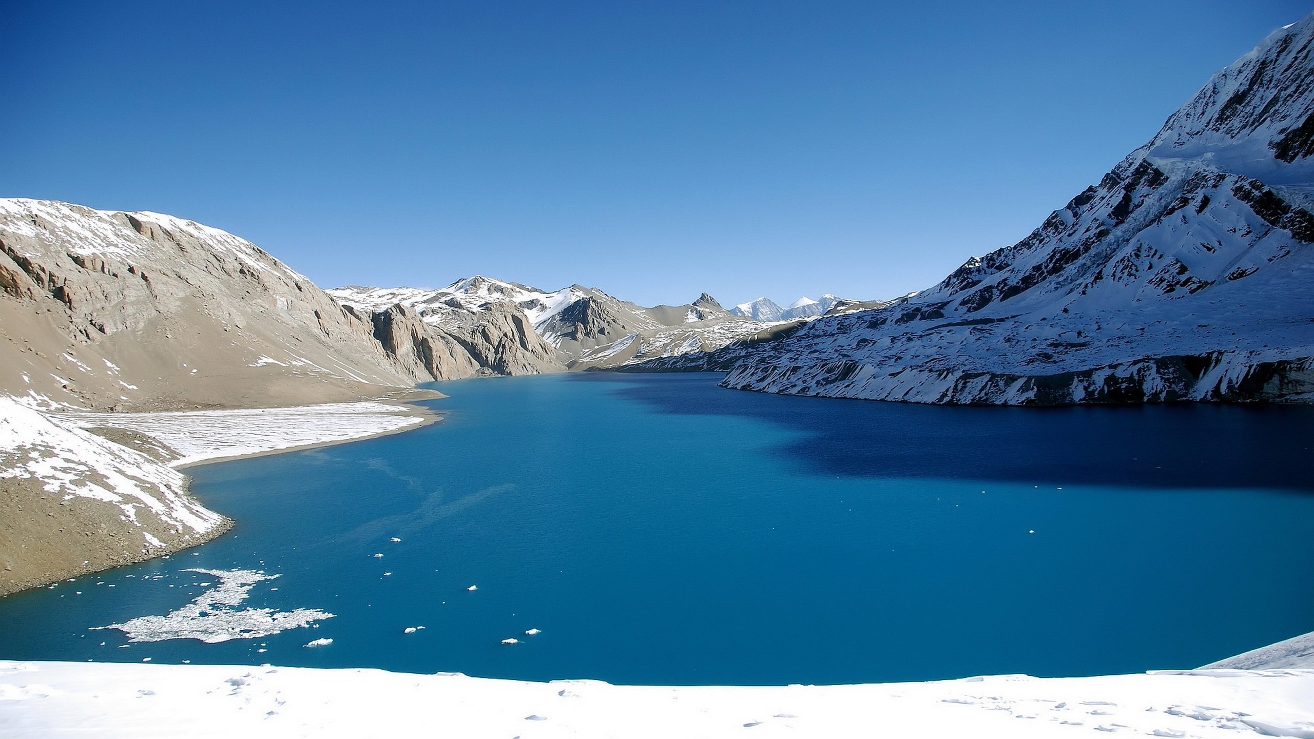 Turquoise lake surrounded by snow-capped mountains HD Wallpaper