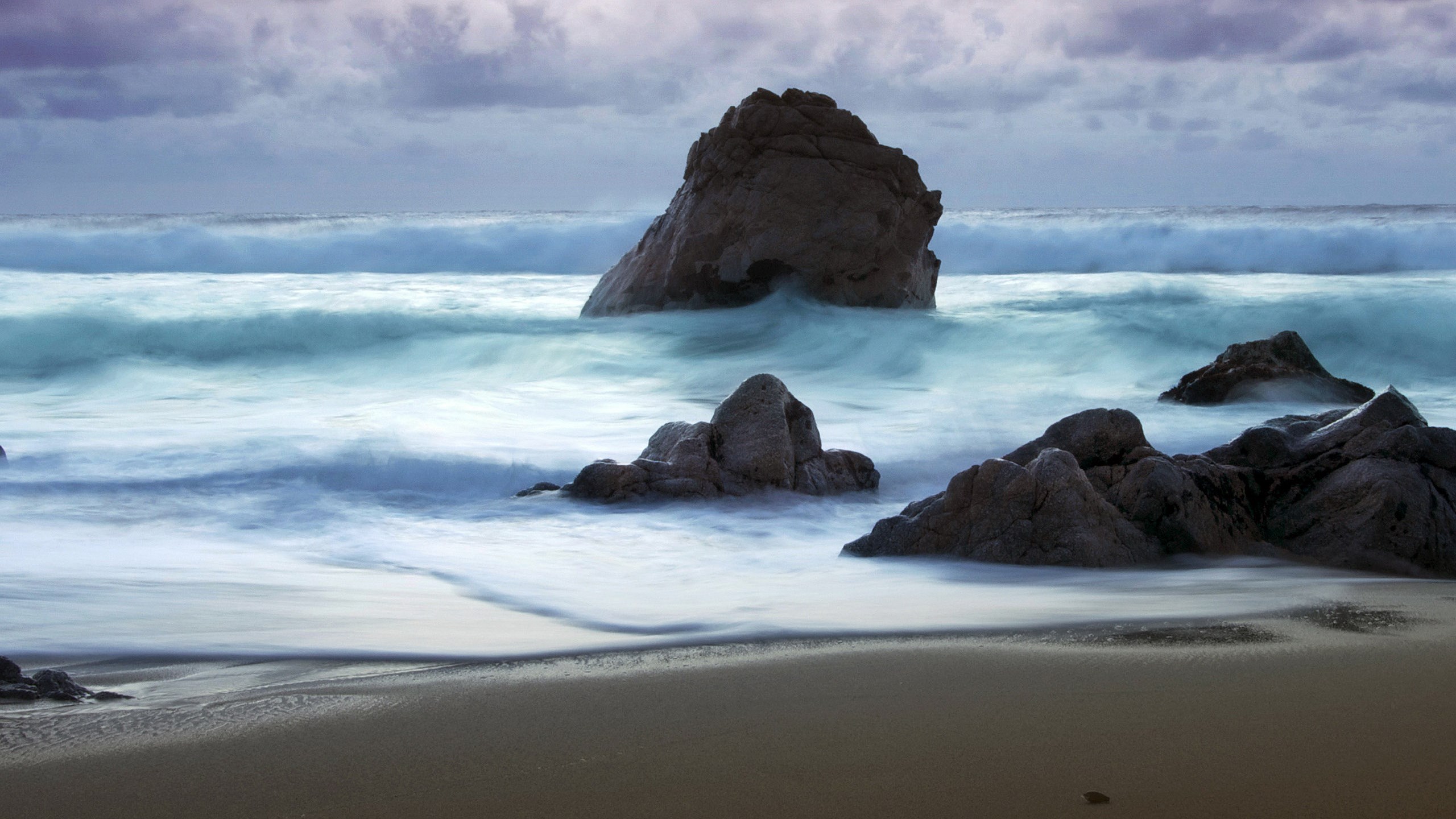 Waves crashing on rocks at a beach HD Wallpaper