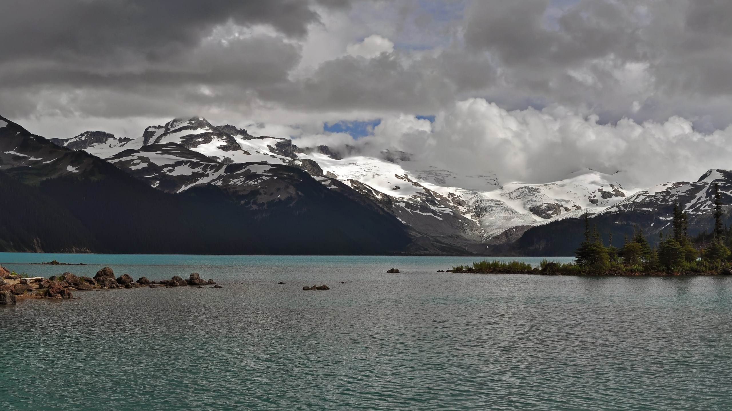 Turquoise lake with snow-capped mountains and clouds HD Wallpaper