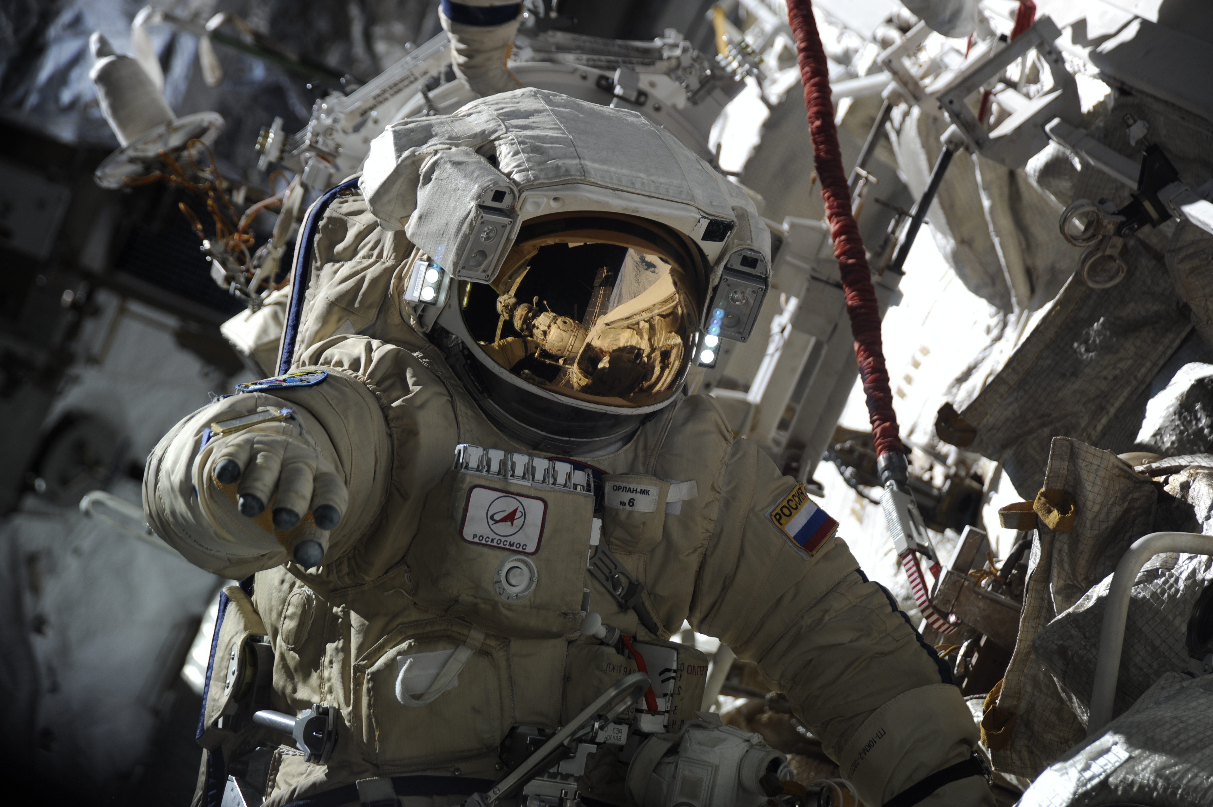 Astronaut in a spacesuit with Roscosmos and Russian flag patches HD Wallpaper