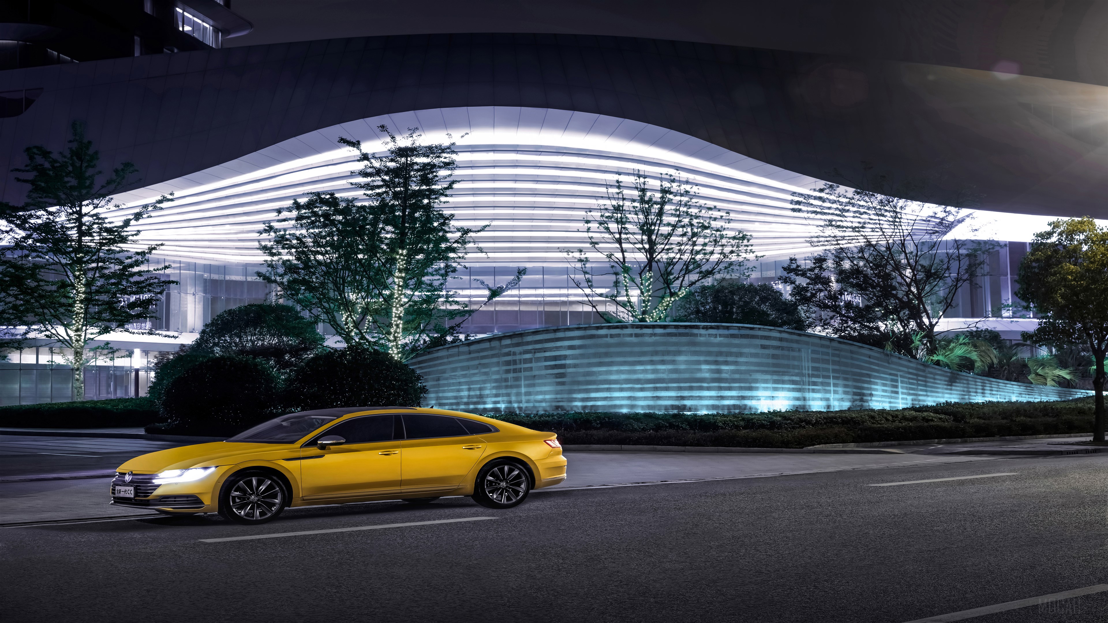 Yellow Volkswagen Arteon parked by a modern building at night HD Wallpaper