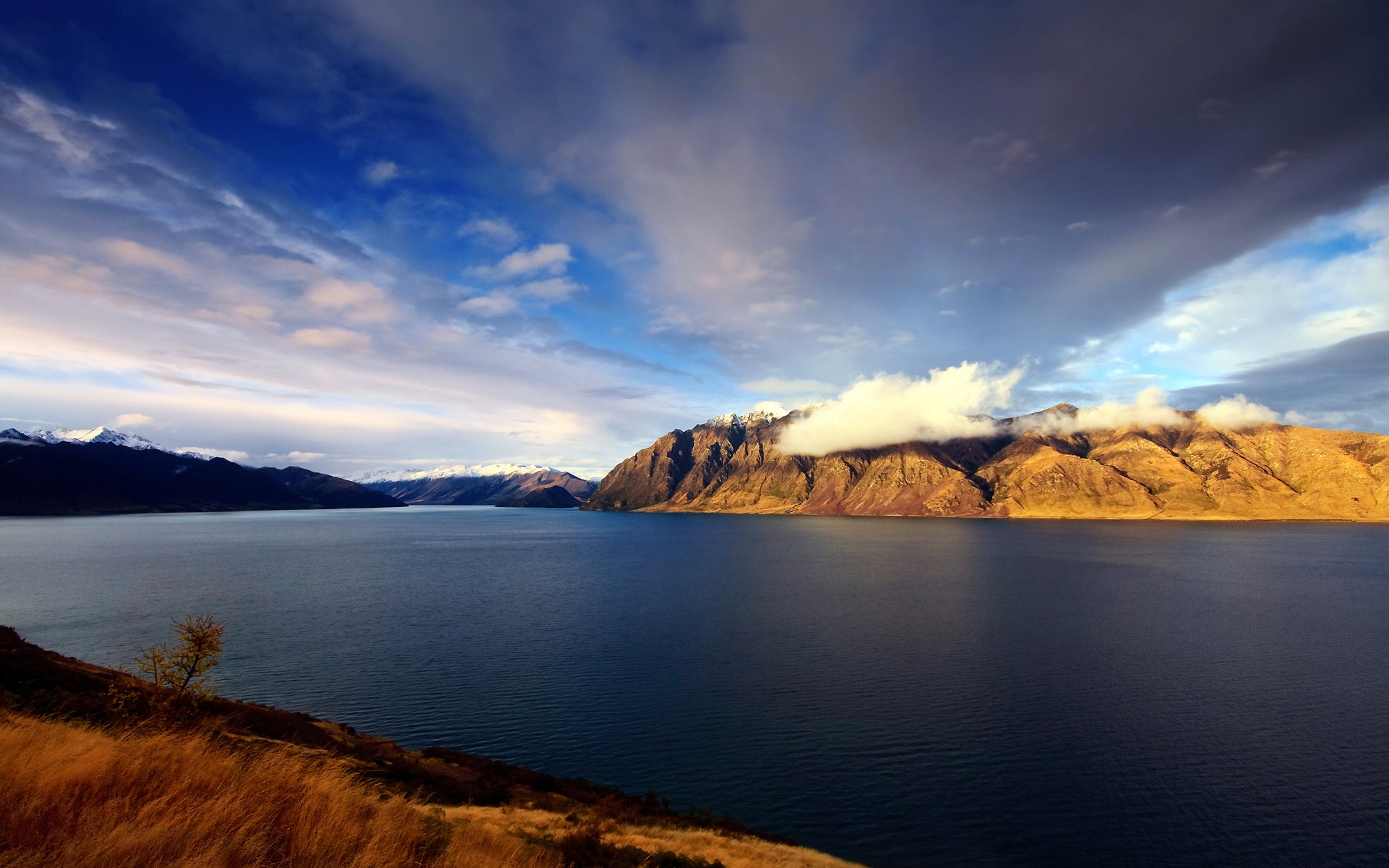 Lake and mountains under a cloudy sky HD Wallpaper
