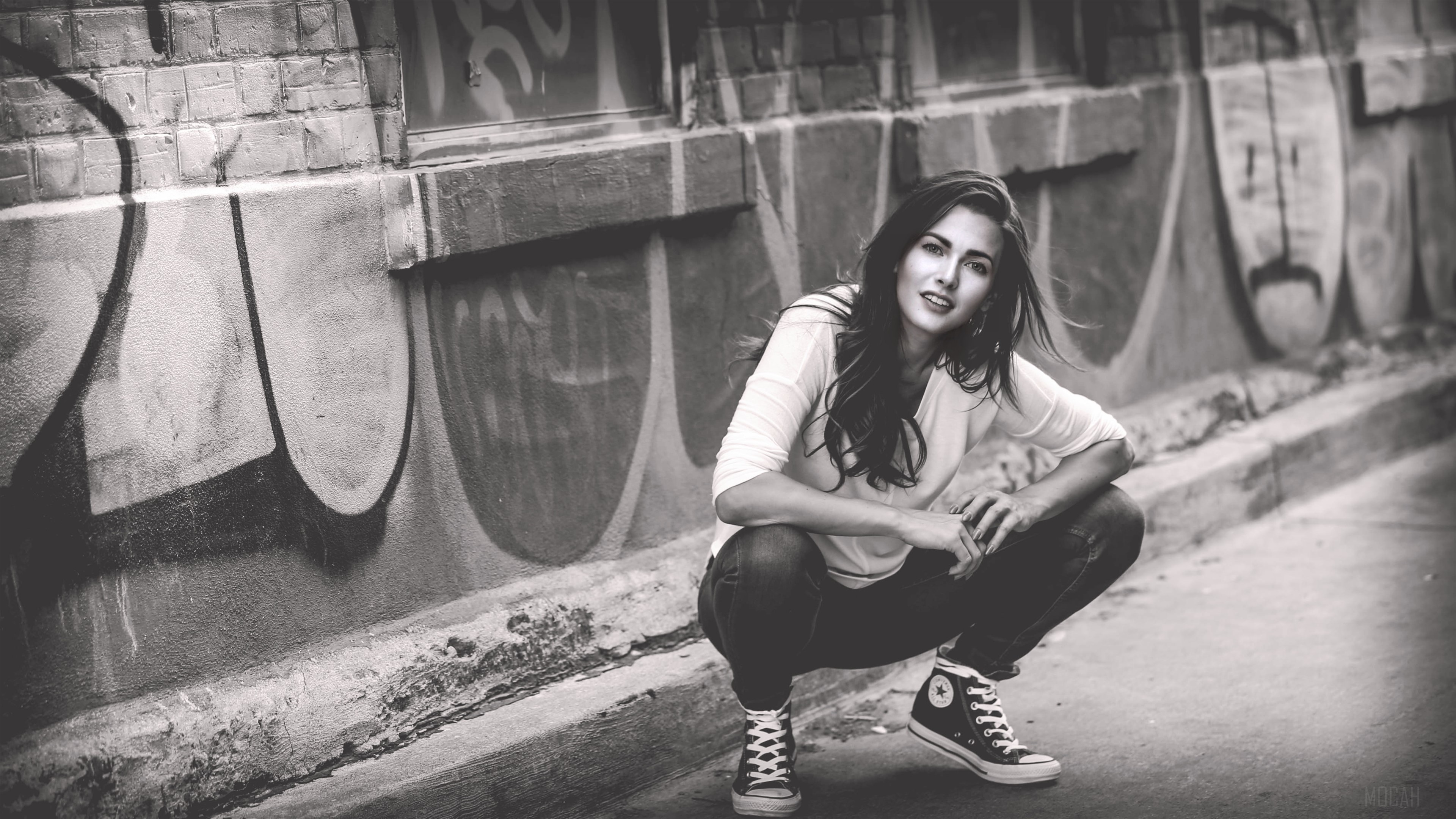 Girl crouching in front of graffiti wall, monochrome 4K HD Wallpaper