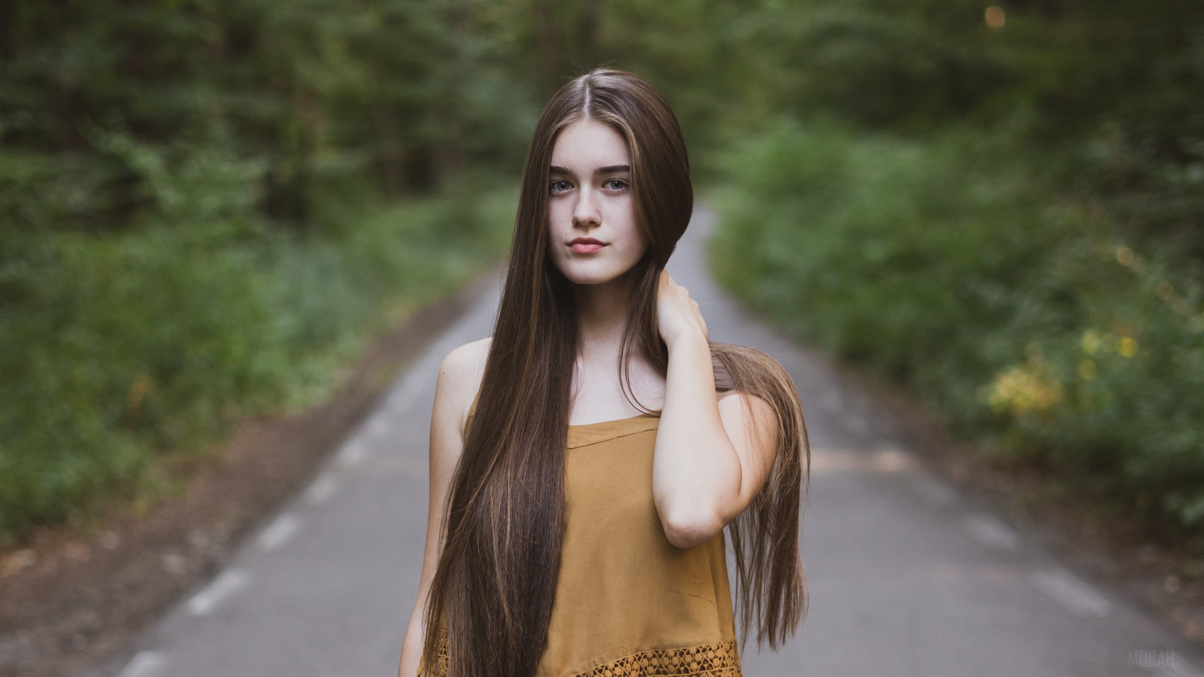 Girl standing on a road path in a forest 4K HD Wallpaper
