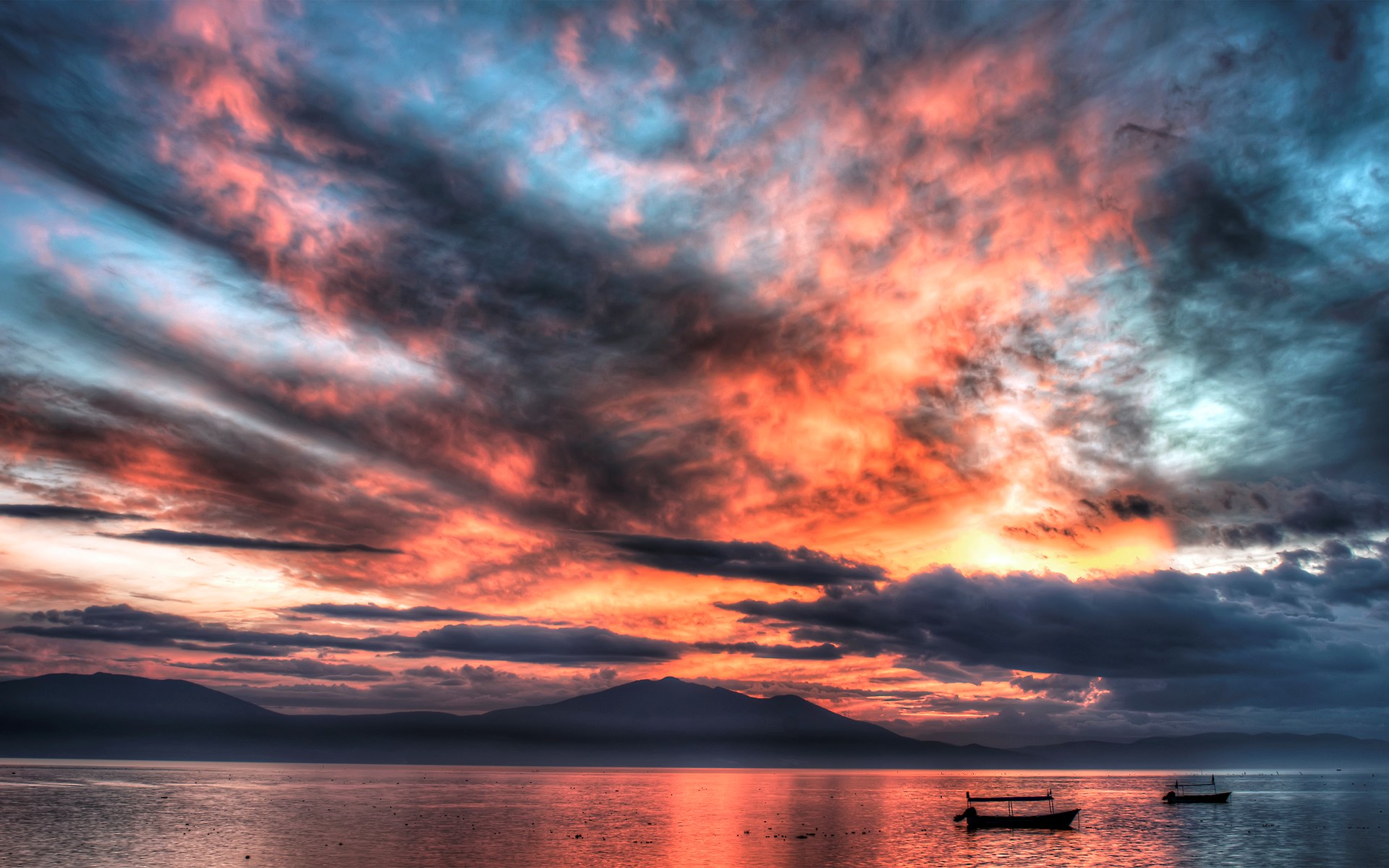 Dramatic sunset over a calm lake with mountains HD Wallpaper