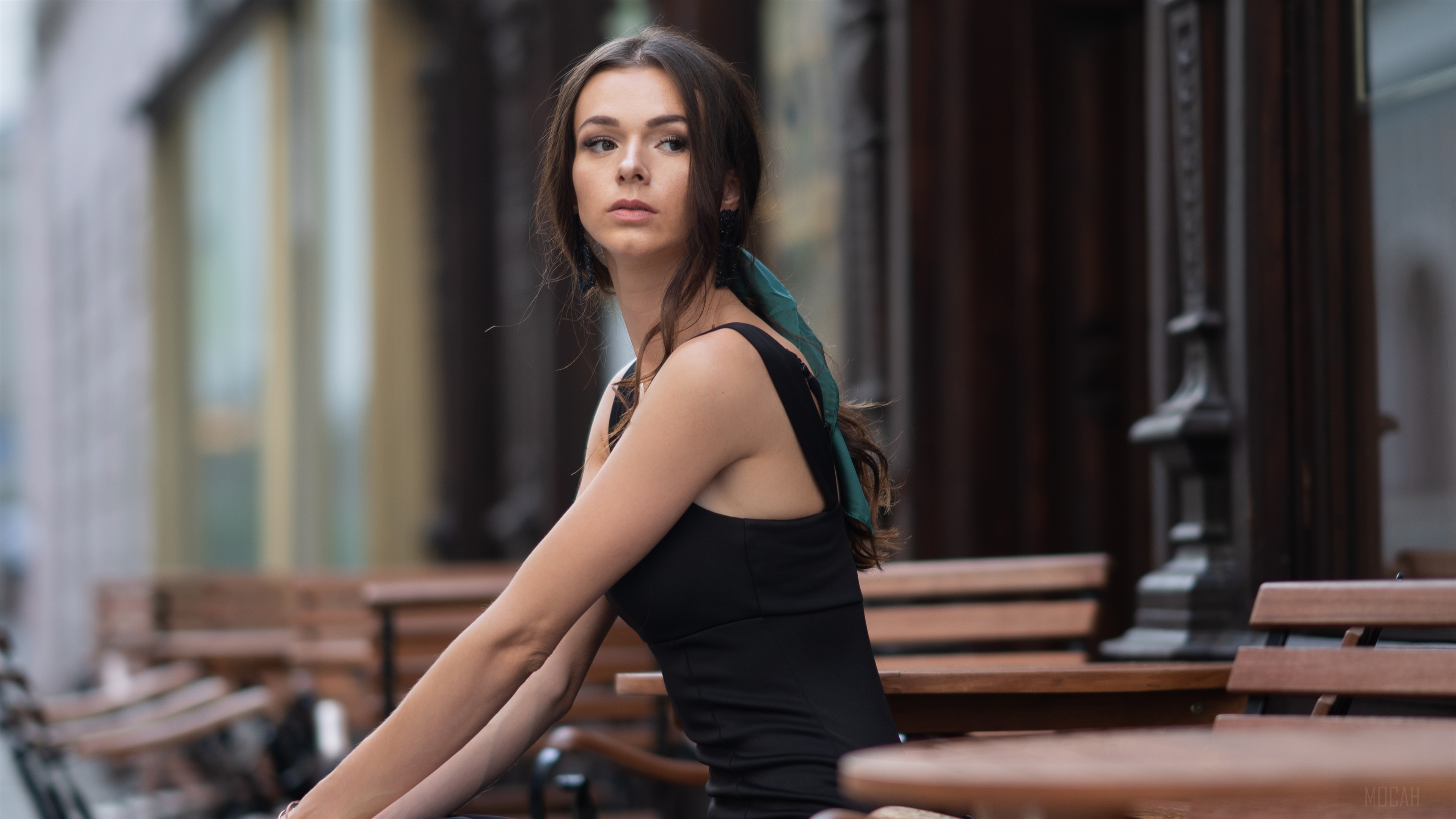 Girl sitting on a bench outdoors, looking away 4K HD Wallpaper