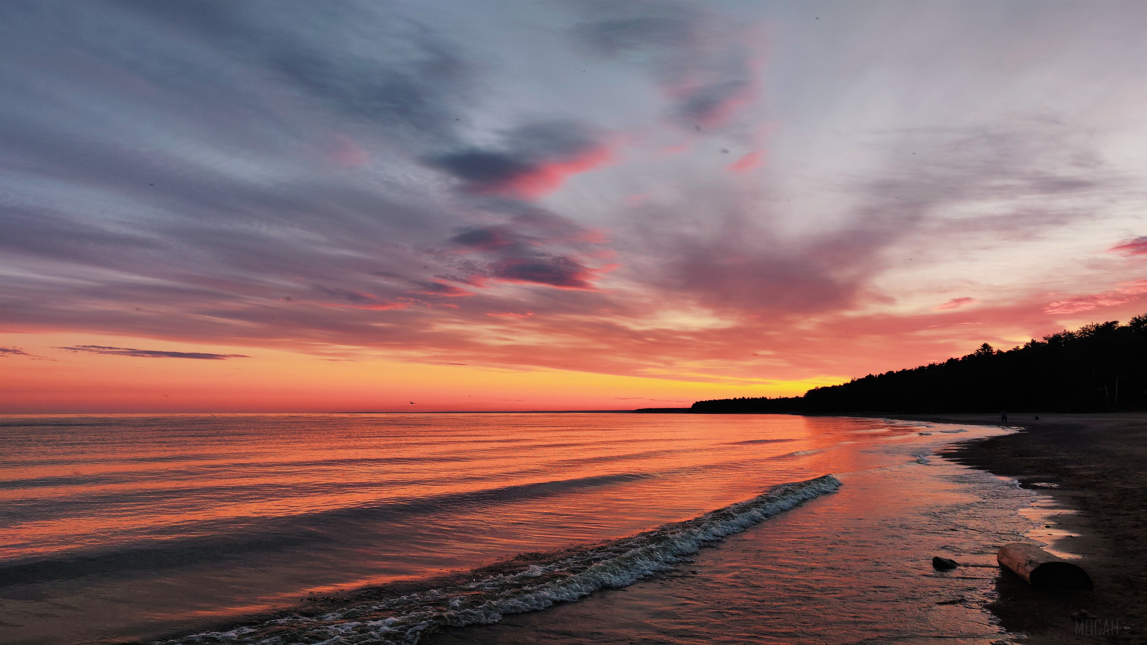 Sunset over a beach with calm ocean waves HD Wallpaper