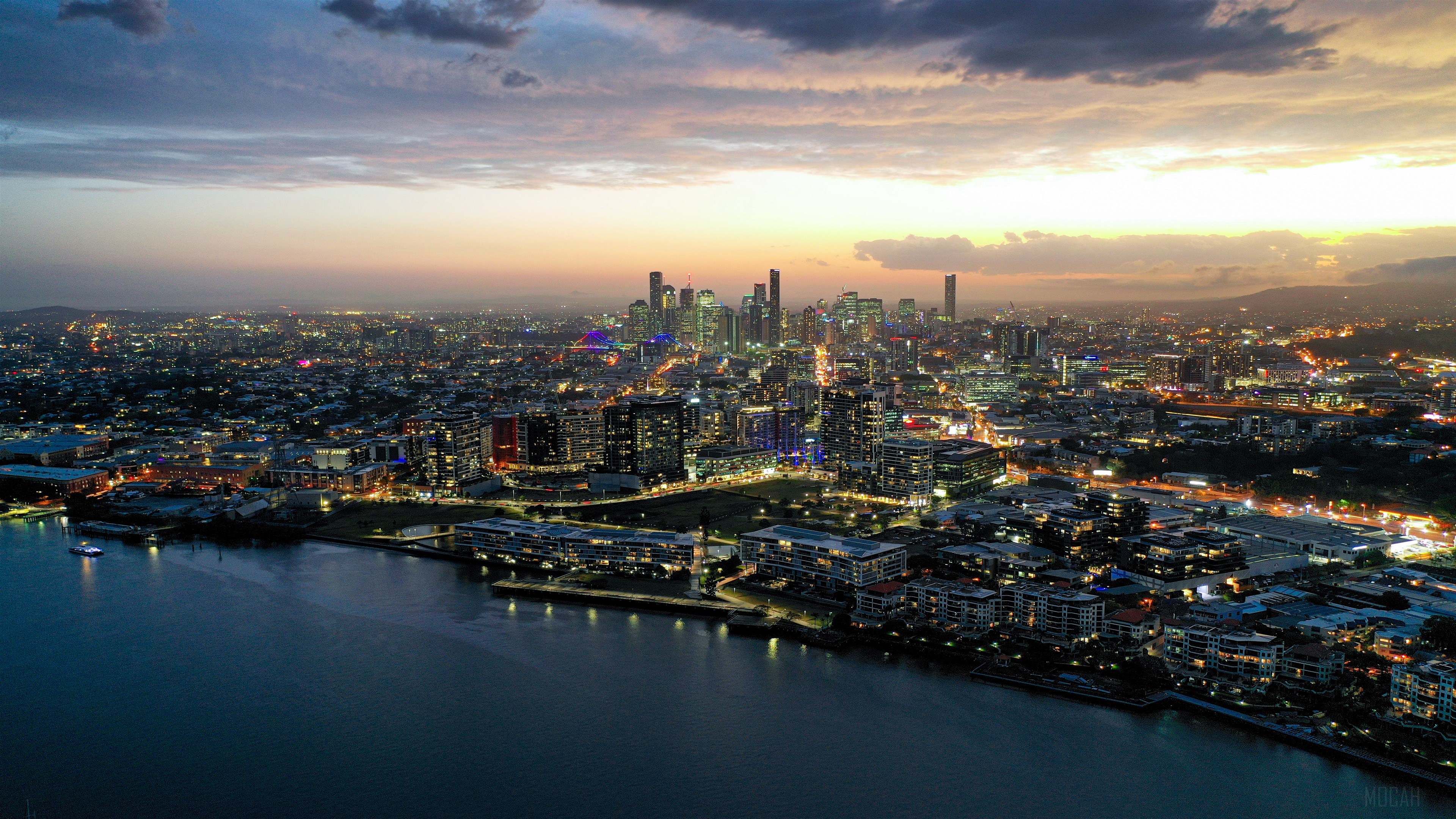 Aerial view of a city skyline at dusk with a river HD Wallpaper
