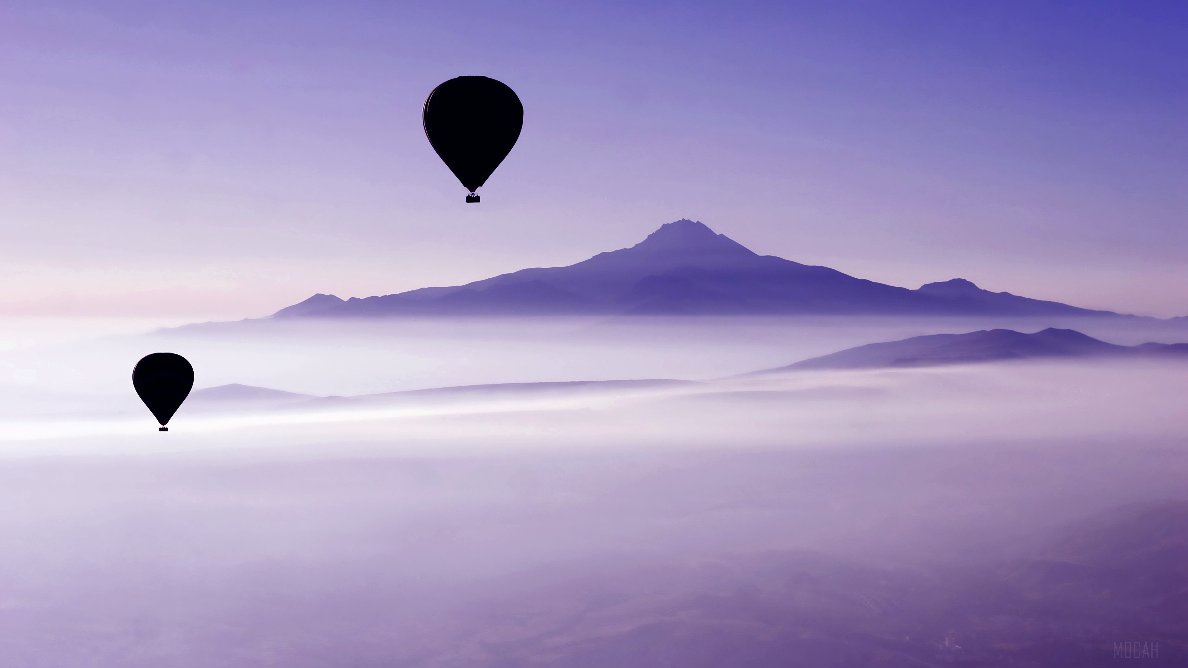 Two hot air balloons over misty mountains HD Wallpaper