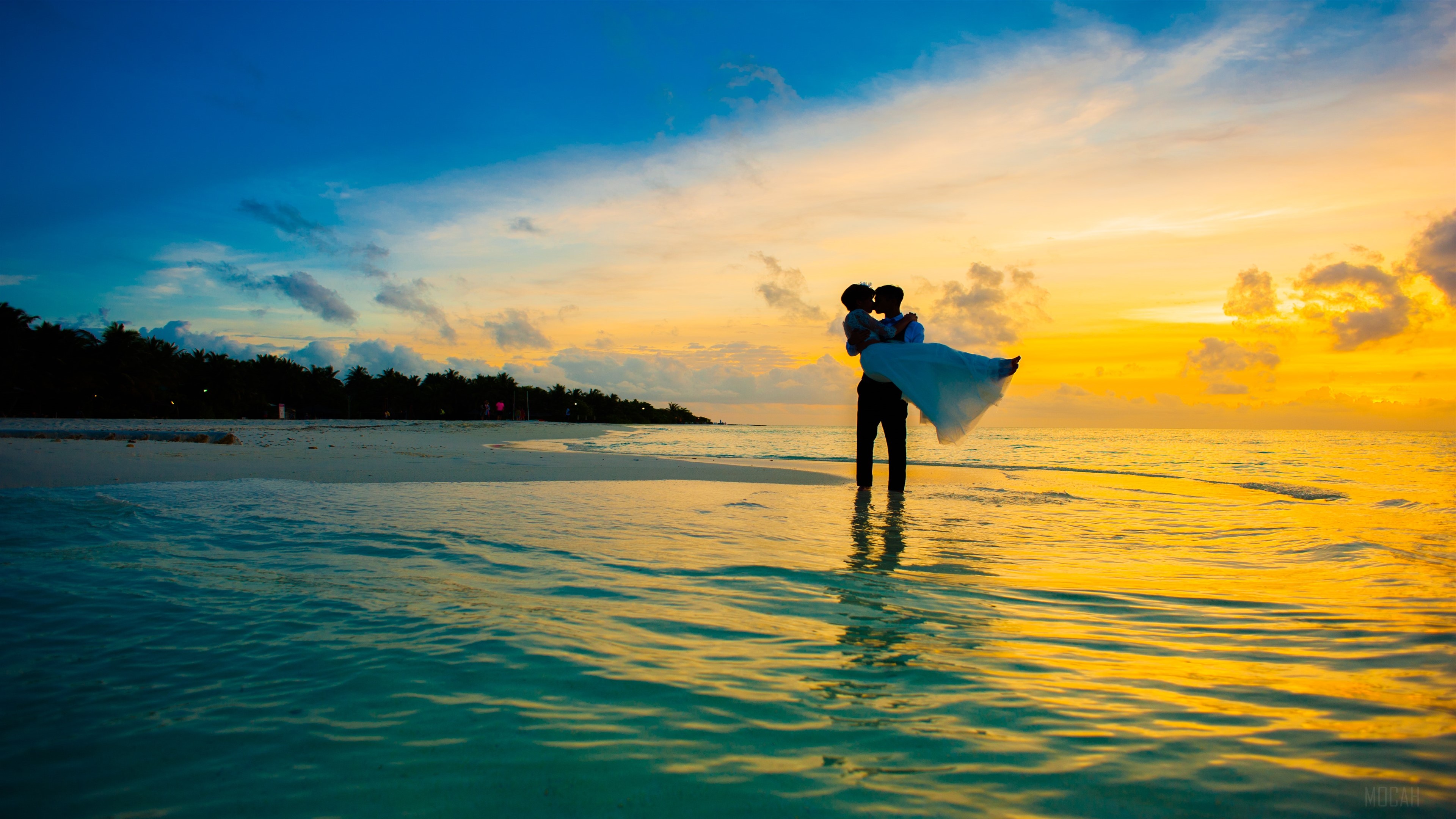 Man carrying woman on beach at sunset 4K HD Wallpaper