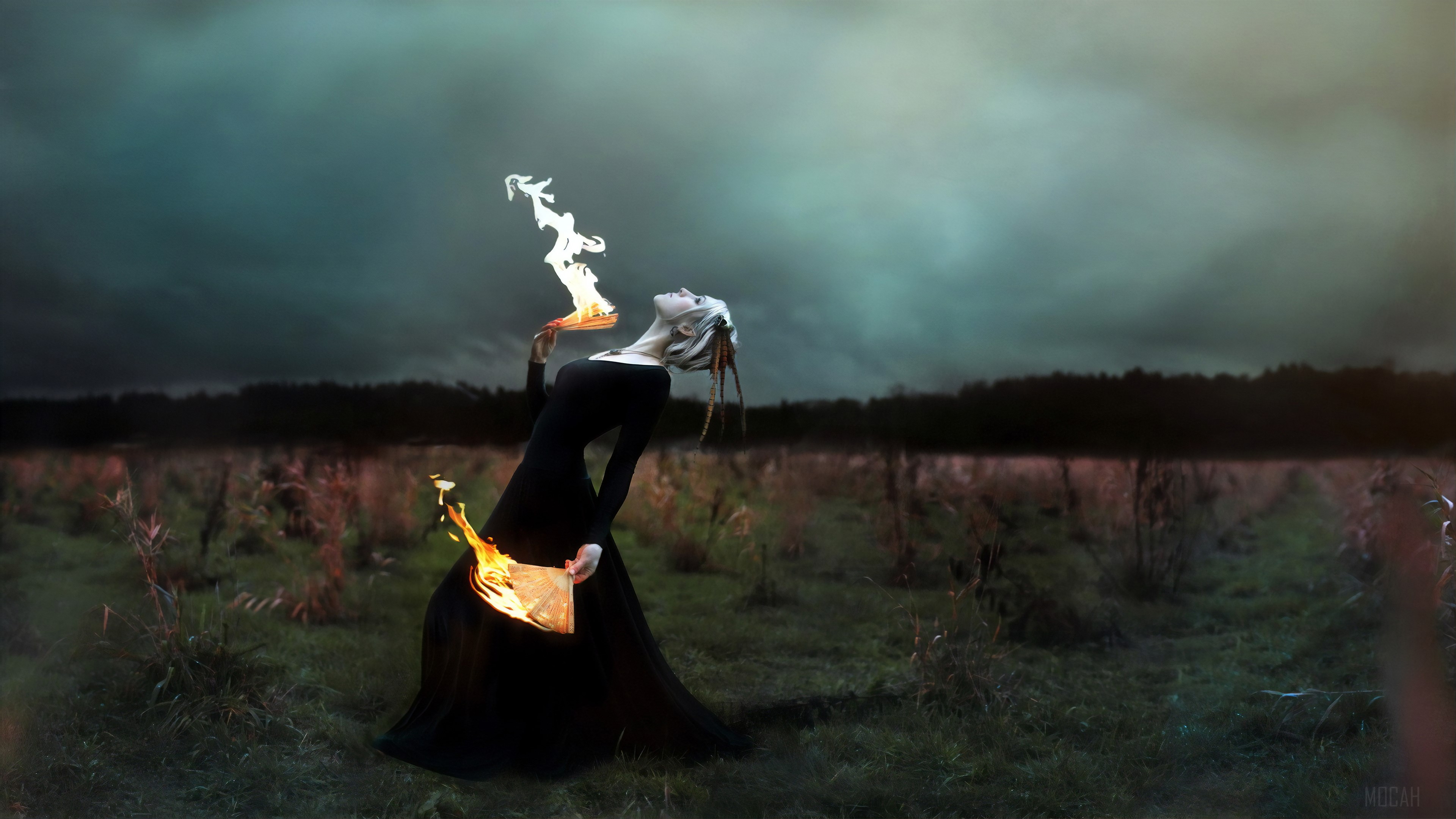 Woman with burning paper in a field HD Wallpaper